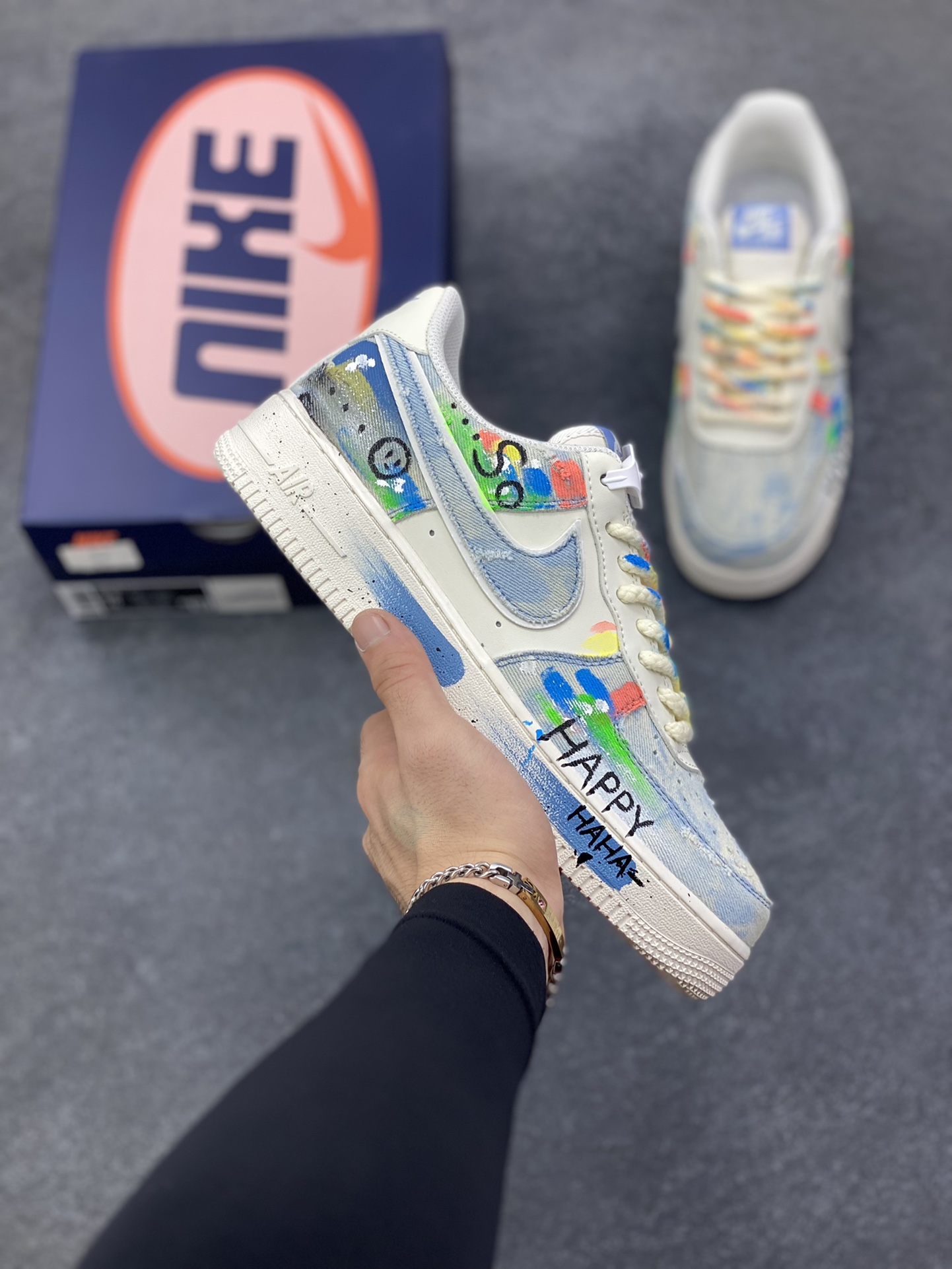 手绘涂鸦“狂想牛仔”Nike Air Force 1 “Fantasy Cowboy”空军一号定制板鞋 这双鞋以米白基底碰撞水洗牛仔面料，破洞与毛边的细节为复古质感注入随性基因。彩色泼墨、“HAPPY”“So……”的手写涂鸦，像是创作者在鞋面上的情绪速写，将快乐与戏谑的灵魂具象化；带彩点的鞋带、鞋侧标志性Swoosh的牛仔拼接，每一处设计都在打破常规，把街头艺术的野性与牛仔的复古肌理揉成独特的潮流语言 货号：CW1888-116 尺码：36 36.5 37.5 38 38.5 39 40 40.5 41 42 42.5 43 44 44.5 45-选品中心