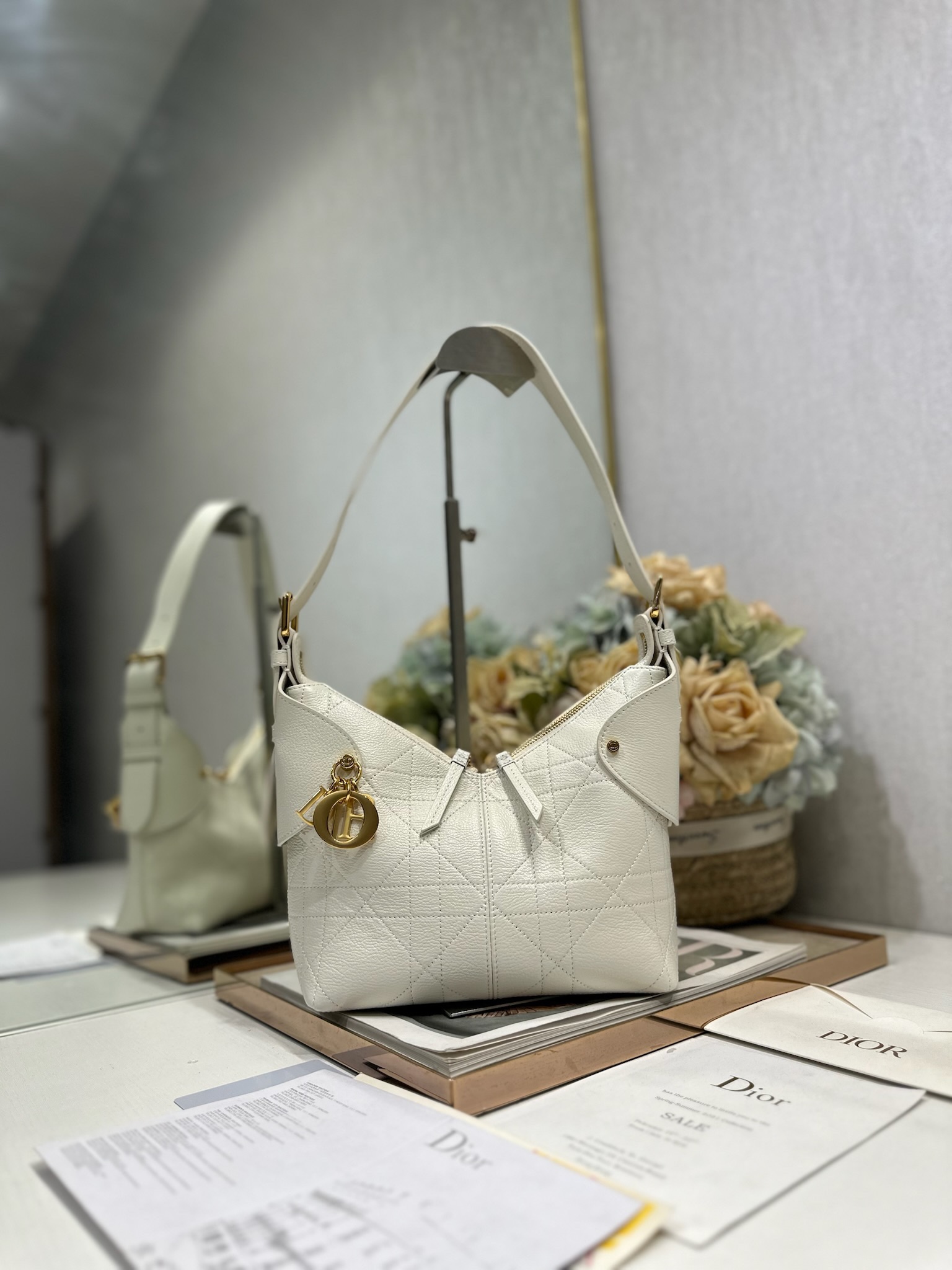 NO:558205,Small Dior Voyage handbag 'Goat pattern white' This Dior Voyage handbag is a new product in the 2026 early spring ready-to-wear series. It combines soft lines and elegant details to create a harmonious silhouette. It is carefully made of white grained cow leather and decorated with flat oversized cannage pattern topstitching, which reinterprets Dior's classic pattern. The soft silhouette is paired with gold-finished metal D.I.O.R.  Charms and expertly crafted leather accents enhance the style and create a wider silhouette, while the main compartment features a secure and practical two-way zipper closure. The small version features an adjustable top handle with buckle for shoulder carry, making it ideal for everyday styling. Two-way zipper closure D.I.O.R. Charm Adjustable leather top handle with gold-finish metal buckle Internal zip pocket   Model 2846 Dimensions 22 x 15 x 9.5 cm (L x H x W) Holds 1 Voyageur slim wallet, 1 card holder, 1 mobile phone, sunglasses and lipstick, Dior, dior, dior, wallets, cowhide19860909小号 Dior Voyage 手袋「山羊纹白色」 这款 Dior Voyage 手袋是二零二六早春成衣系列新品,融合柔软线条和高雅的细节,打造协调的廓形.采用白色粒面牛皮革精心制作,饰以扁平超大藤格纹缉面线,焕新演绎 Dior 的经典图案.柔软廓形搭配金色饰面金属 D.I.O.R. 吊饰和匠心打造的皮革点缀提升格调,令造型更加挺阔,主隔层则采用安全实用的双向拉链开合.小号款式,顶部手柄搭配可调节搭扣,可肩背,是日常造型的理想良伴. 双向拉链开合 D.I.O.R. 吊饰 可调节顶部皮革手柄,搭配金色饰面金属搭扣 内部拉链口袋 型号2846 尺寸22 x 15 x 9.5 厘米（长 x 高 x 宽） 可收纳 1 个 Voyageur 细窄钱包、1 个卡夹、1 部手机、太阳眼镜和唇膏,迪奥,dior,dior,wallets,cowhide,Bag