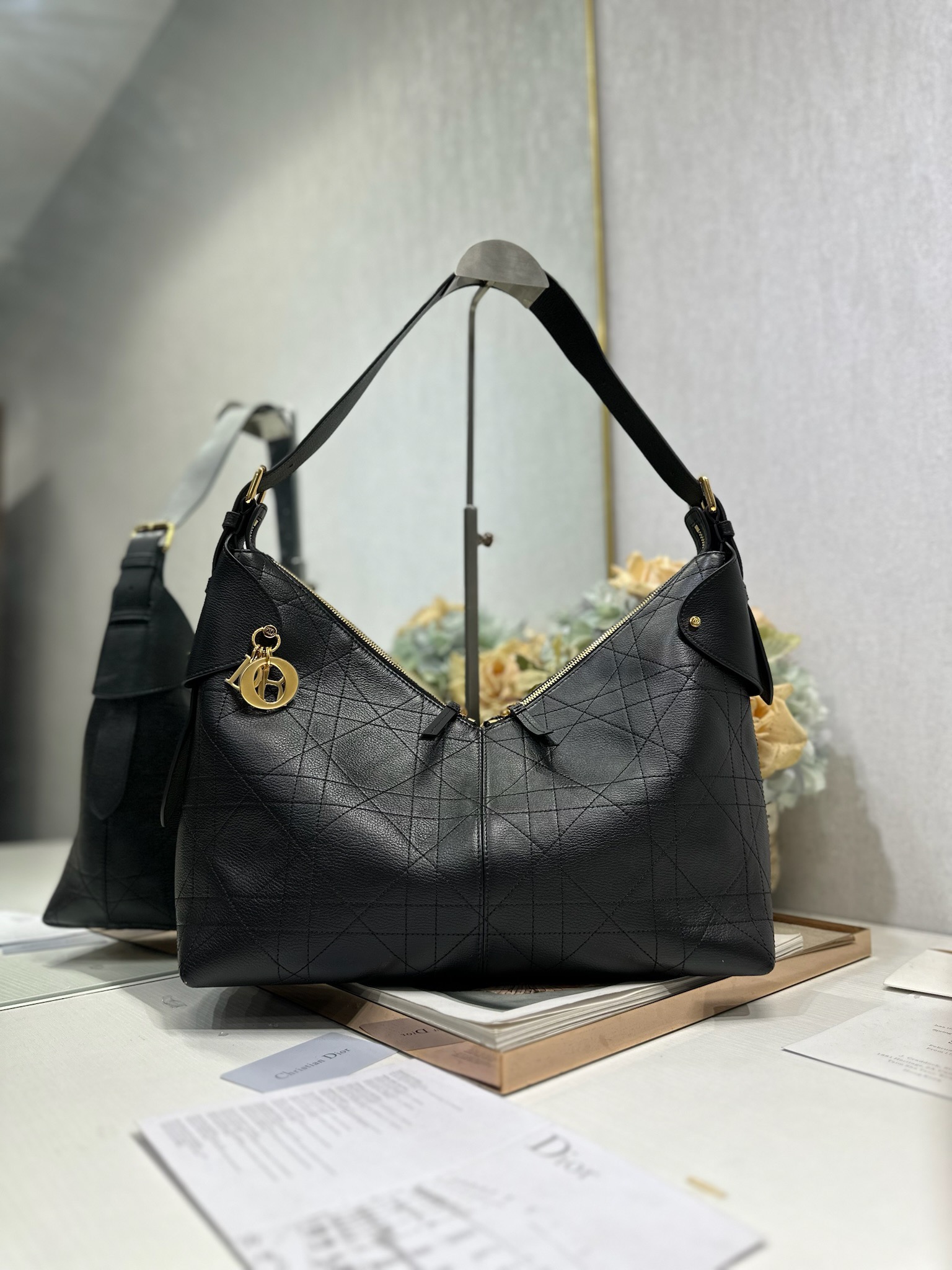 NO:558183,Large Dior Voyage handbag 'Goat pattern black' This Dior Voyage handbag is a new product in the 2026 early spring ready-to-wear series. It combines soft lines and elegant details to create a coordinated dumpling bag silhouette. It is carefully made of black pebbled cow leather and decorated with flat oversized cannage pattern topstitching, which reinterprets Dior's classic pattern. The soft silhouette is paired with gold-finished metal D.I.O.R.  Charms and expertly crafted leather accents enhance the style and make the look wider, while the main compartment features a secure, practical two-way zipper closure. The large style has an adjustable top handle with buckle that can be worn over the shoulder, making it ideal for everyday styling. Two-way zipper closure D.I.O.R. Charm Adjustable leather top handle with gold-finish metal buckle Internal zip pocket   Model 2844 Dimensions 34 x 22 x 13 cm (L x H x W) Holds 1 small bag, 1 wallet, 1 mobile phone, 1 card holder, sunglasses and lipstick, Dior, dior, dior, wallets, cowhide19860909大号 Dior Voyage 手袋「山羊纹黑色」 这款 Dior Voyage 手袋是二零二六早春成衣系列新品,融合柔软线条和高雅的细节,打造协调的水饺包廓形.采用黑色荔面牛皮革精心制作,饰以扁平超大藤格纹缉面线,焕新演绎 Dior 的经典图案.柔软廓形搭配金色饰面金属 D.I.O.R. 吊饰和匠心打造的皮革点缀提升格调,令造型更加挺阔,主隔层则采用安全实用的双向拉链开合.大号款式,顶部手柄搭配可调节搭扣,可肩背,是日常造型的理想良伴. 双向拉链开合 D.I.O.R. 吊饰 可调节顶部皮革手柄,搭配金色饰面金属搭扣 内部拉链口袋 型号2844 尺寸34 x 22 x 13 厘米（长 x 高 x 宽） 可收纳 1 个小包、 1 个钱包、1 部手机、1 个卡夹、太阳眼镜和唇膏,迪奥,dior,dior,wallets,cowhide,Bag