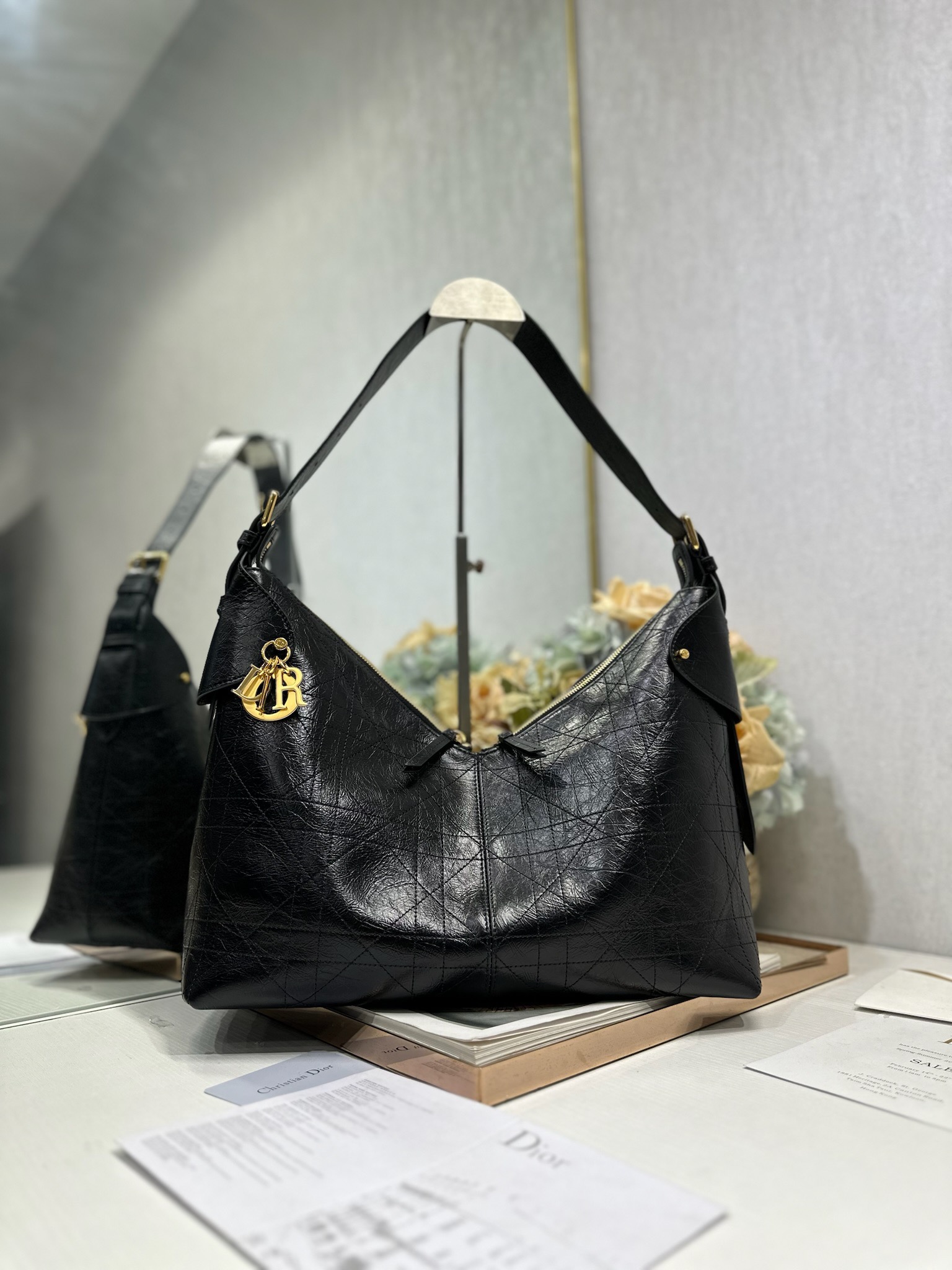 NO:558204,Large Dior Voyage Handbag 'Pleated Black' This Dior Voyage handbag is a new product in the 2026 Early Spring ready-to-wear series. It combines soft lines and elegant details to create a harmonious dumpling bag silhouette. It is carefully made of black pleated cow leather and decorated with flat oversized cannage topstitching, which reinterprets Dior's classic pattern. The soft silhouette is paired with gold-finished metal D.I.O.R.  Charms and expertly crafted leather accents enhance the style and make the look wider, while the main compartment features a secure, practical two-way zipper closure. The large style has an adjustable top handle with buckle that can be worn over the shoulder, making it ideal for everyday styling. Two-way zipper closure D.I.O.R. Charm Adjustable leather top handle with gold-finish metal buckle Internal zip pocket   Model 2844 Dimensions 34 x 22 x 13 cm (L x H x W) Holds 1 small bag, 1 wallet, 1 mobile phone, 1 card holder, sunglasses and lipstick, Dior, dior, dior, wallets, cowhide19860909大号 Dior Voyage 手袋「褶皱黑色」 这款 Dior Voyage 手袋是二零二六早春成衣系列新品,融合柔软线条和高雅的细节,打造协调的水饺包廓形.采用黑色褶皱牛皮革精心制作,饰以扁平超大藤格纹缉面线,焕新演绎 Dior 的经典图案.柔软廓形搭配金色饰面金属 D.I.O.R. 吊饰和匠心打造的皮革点缀提升格调,令造型更加挺阔,主隔层则采用安全实用的双向拉链开合.大号款式,顶部手柄搭配可调节搭扣,可肩背,是日常造型的理想良伴. 双向拉链开合 D.I.O.R. 吊饰 可调节顶部皮革手柄,搭配金色饰面金属搭扣 内部拉链口袋 型号2844 尺寸34 x 22 x 13 厘米（长 x 高 x 宽） 可收纳 1 个小包、 1 个钱包、1 部手机、1 个卡夹、太阳眼镜和唇膏,迪奥,dior,dior,wallets,cowhide,Bag