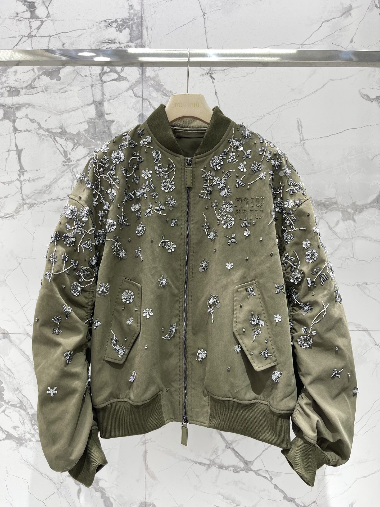 NO:890595,*Miu Miu's new autumn and winter baseball jacket with heavy beading embroidery flowers. Heavy hand sewing. One worker sews a ready-made garment by hand in 3 days. The order has been returned and shipped. The lining is 100 grams of down cotton, heavy embroidery, so exquisite that it screams. The heavy beading embroidered flowers all over the field are amazing!  Every flower seems to have been given life and blooms vividly on the jacket. The beads are full and sparkle charmingly under the light, just like the twinkling stars in the night sky. The embroidery stitching is delicate and exquisite, and the lines are smooth and natural. It can be seen that it was made by a master. The heavy design makes the whole jacket full of artistic and high-end sense. It is not the kind of baseball jersey that cheap embroidery can compare with. It is youthful and energetic.  It adopts the classic baseball jersey version, which has a youthful and energetic atmosphere. Wearing it will instantly take you back to your school days. The loose version is very tolerant to the body shape, and can be easily controlled whether you are slightly fat or thin. It can also modify the figure well, covering the small flesh on the arms and belly, making you look slimmer. The rib design on the cuffs and hem not only increases the three-dimensional sense of the jacket, but also prevents cold wind from entering, keeping you warm and fashionable. A versatile tool, you can change your style at will.  It is a versatile artifact that can be matched with various items. Pair it with a simple white T-shirt and jeans to create a casual street style; pair it with a dress and short boots to turn it into a sweet and cute girly style; pair it with a shirt and suit pants to create a smart workplace style. A jacket can meet your many different dressing needs, allowing you to wear a different style every day. High-quality fabrics, comfortable and warm  Made of high-quality blended fabric, it feels soft and soft, and is super comfortable to wear next to the body. It has good warmth retention and breathability. When worn in autumn and winter, it can resist the cold wind without making you feel stuffy. Code number: 36 38 40 42, Miu Miu-clothing, boots, skirts, jeans, jackets & coats, shirts, tees, t-shirt, down jacket, business suit,19860909*缪缪秋冬新款重工钉珠刺绣花朵棒球衣外套 重工手缝 一个工人3天手缝一件成衣 一直返单出货中 内胆100克羽绒棉,重工刺绣,精致到尖叫 满幅的重工钉珠刺绣花朵惊艳到了！每一朵花都像是被赋予了生命,栩栩如生地绽放在外套上.钉珠颗颗饱满,在光线下闪烁着迷人的光芒,仿佛夜空中闪烁的繁星.刺绣的针法细腻又精湛,线条流畅自然,一看就是出自大师之手.重工的设计让整件外套充满了艺术感和高级感,完全不是那种廉价刺绣能比的 棒球衣版型,青春又活力 采用了经典的棒球衣版型,这种版型自带一种青春活力的气息,穿上它瞬间让你回到学生时代.宽松的版型对身材的包容性很强,不管你是微胖还是偏瘦,都能轻松驾驭.还能很好地修饰身材,遮住手臂和肚子上的小肉肉,让你看起来更显瘦.袖口和下摆的罗纹设计,不仅增加了外套的立体感,还能防止寒风灌入,保暖又时尚. 百搭神器,风格随心换 百搭神器,可以和各种单品进行搭配.里面搭配一件简单的白色T恤和牛仔裤,就能打造出休闲随性的街头风；搭配一条连衣裙和短靴,又能秒变甜美可爱的少女风；搭配一件衬衫和西装裤,还能营造出干练利落的职场风.一件外套就能满足你多种不同的穿搭需求,让你每天都能穿出不一样的风格. 优质面料,舒适又保暖 采用了高品质的混纺面料,摸起来软软乎乎的,贴身穿超级舒服.具有良好的保暖性和透气性,在秋冬季节穿,既能抵御寒风,又不会让你感到闷热 码数:36 38 40 42,缪缪-服装,boots,skirts,jeans,jackets & coats,shirts,tees，t-shirt,down jacket,business suit,,Women's clothing