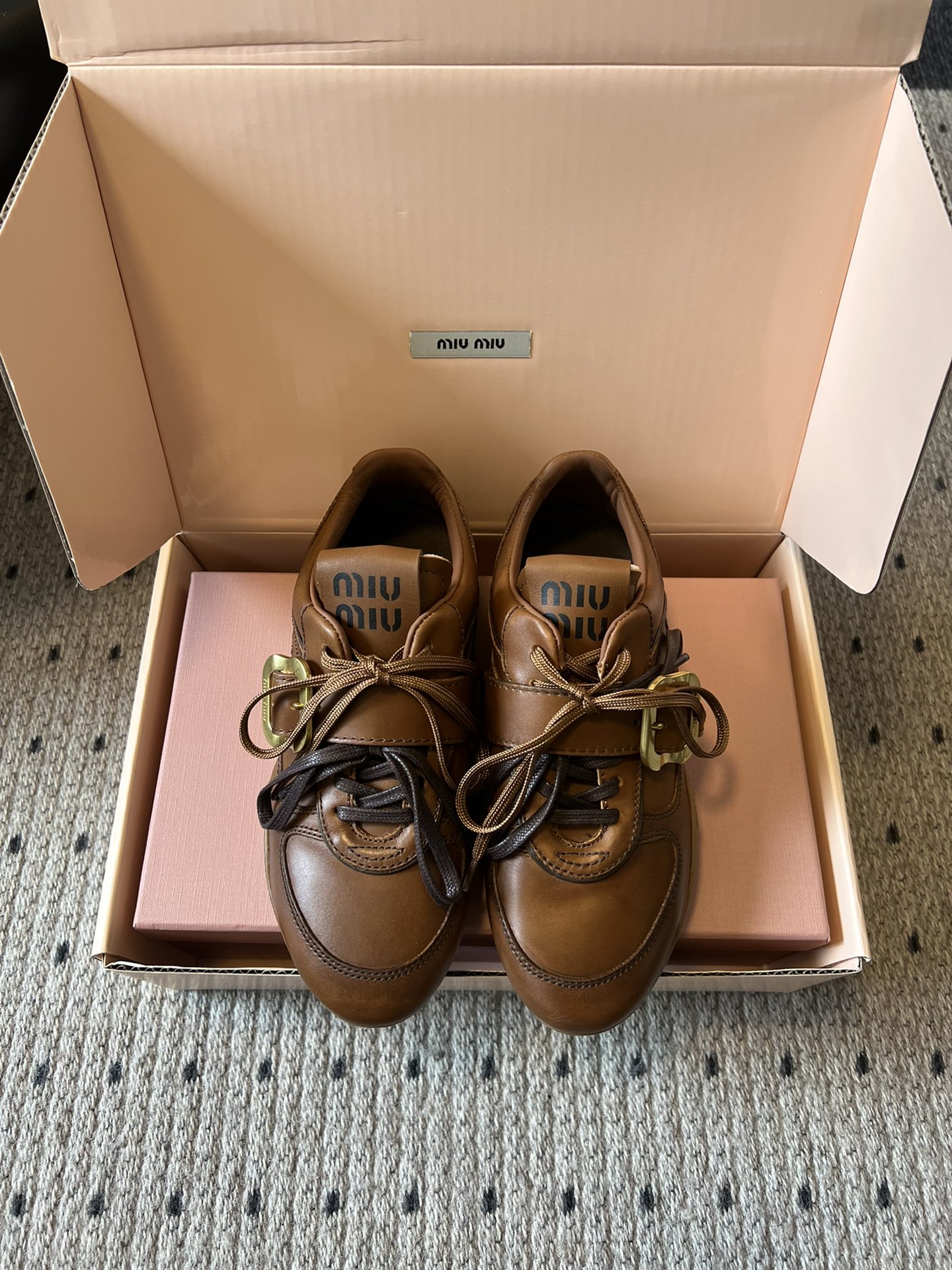 NO:563173,Miu Mi* 25FW deck shoes from Wanguan are artistic retro leather thin-soled De Xun shoes that combine retro and light luxury textures. The brown leather upper shows a delicate old luster. The double-layer design of the shoelaces and metal buckles (the metal buckles have an old brass texture) is highly recognizable. The brand logo on the tongue strengthens the brand genes, and the overall shape is retro yet refined.  Made of high-quality genuine leather, soft to the touch and full of vintage and distressed texture details, fine stitching, and the distressed treatment of the metal buckle complements the leather texture, combining durability and aesthetic value. The upper is colored waxed oiled calfskin, the lining is all goat/sheep leather, outsole TPU outsole Size35-40, leather shoes, miumiu, cowhide, sheepskin, sheep19860909莞产 Miu Mi* 25FW deck shoes文艺复古皮革薄底德训鞋 融合复古与轻奢质感,棕色真皮鞋面呈现出细腻的做旧光泽,鞋带与金属扣带的双层设计（金属扣为做旧黄铜质感）极具辨识度,鞋舌处的品牌标识强化了品牌基因,整体造型复古又不失精致感. 采用优质真皮材质,触感柔软且富有复古做旧的纹理细节,缝线工艺精细,金属扣的做旧处理与皮革质感相得益彰,兼具耐用性与美学价值. 鞋面擦色蜡皮油面小牛皮 内里全羊京/绵羊皮 大底TPU大底 Size35-40,皮鞋,miumiu,cowhide,sheepskin,sheep,Women's Shoes