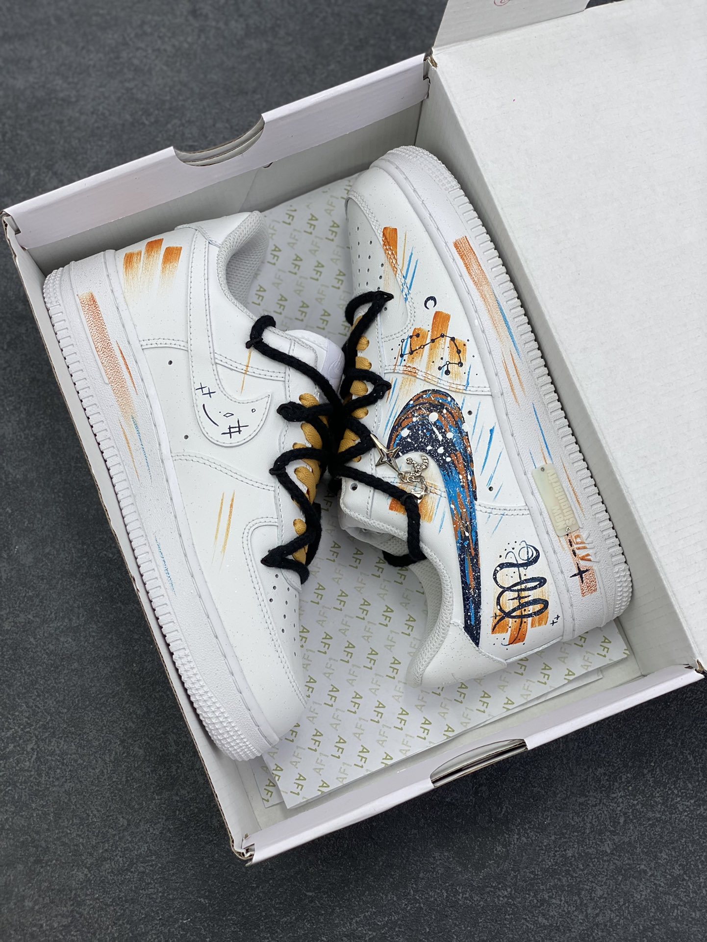 图片[9]-手绘涂鸦“天蝎座”十二星座系列 Nike Air Force 1 “Scorpio”空军一号定制板鞋 纯白鞋身化作星穹画布，泼墨般的蓝橙笔触勾勒天蝎座的神秘轮廓，星轨纹路在鞋侧肆意延展，双色系鞋带缠绕出不羁风格，专属星座挂饰更添细节温度。它不止是一双鞋，更是天蝎特质的具象表达——冷冽中藏着热烈，小众里透着锋芒，将星座文化、手绘艺术与街头潮流熔于一炉，让每一步都似在星际间留下独特轨迹 货号：星座10241122 尺码：36 36.5 37.5 38 38.5 39 40 40.5 41 42 42.5 43 44 44.5 45-选品中心