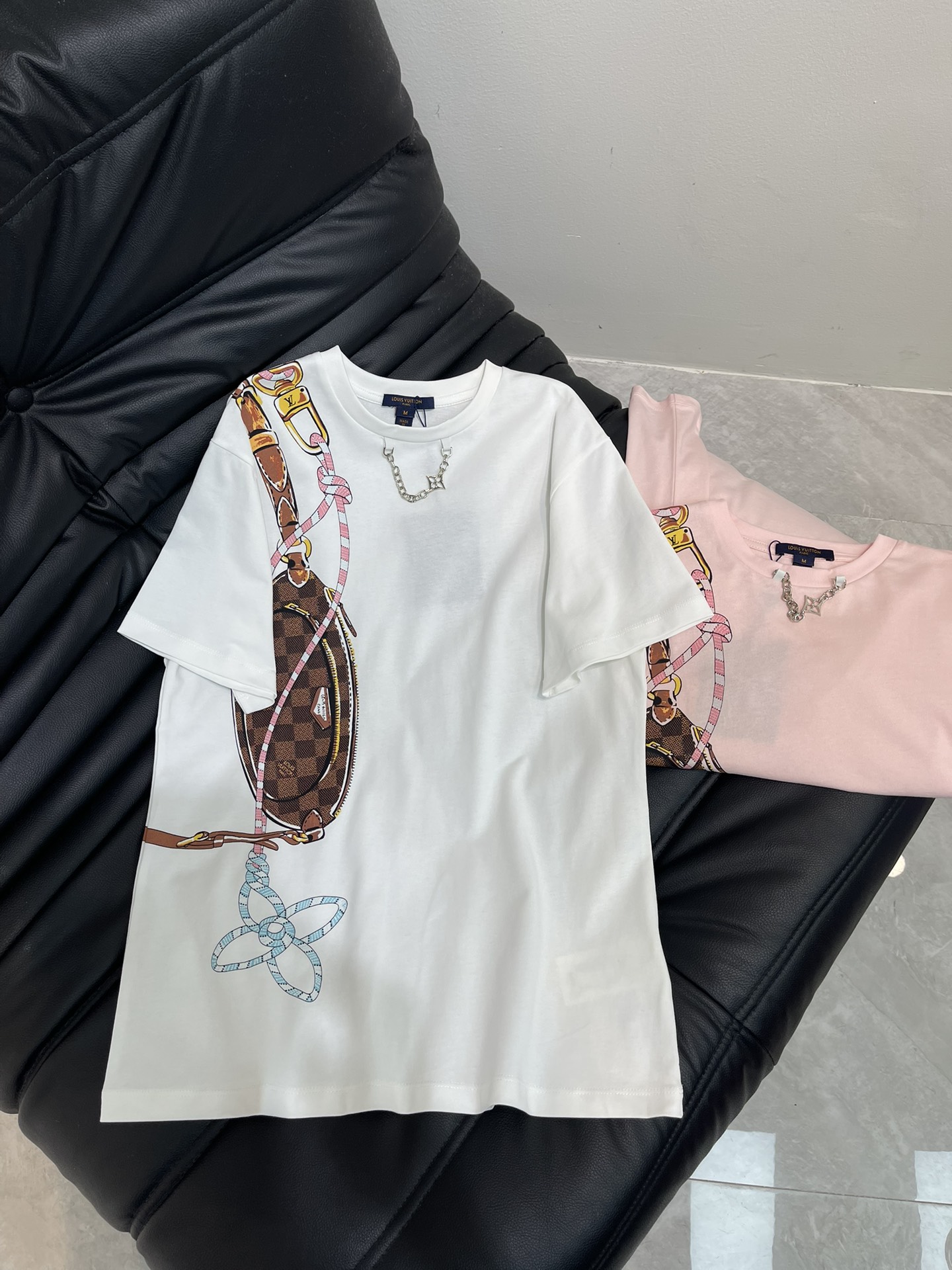 NO:570638,Louis  Vuitto*'s new chain round neck printed short-sleeved T-shirt. Customized YB twill cotton material, breathable and comfortable, full of texture. Regular short-sleeved T-shirt cut, highlighting the brand style. Made of heavyweight pure cotton, full of drape, showing a slimming visual effect. The whole body is pink, cute and lively, and the chest is sharp  The printing process is used to restore the colors, and the key colors create a three-dimensional appearance of the outer outline of the hand-painted jacquard pattern, interspersed with the four-leaf clover pattern. The style echoes the letter chain engraved on the neckline and extends to the back shoulder, making the fashion and high-end sense immediately appear, creating a fashionable and relaxed personality, which can be worn alone and stylish. SML  A,,louis vuitton,T-shirt,tees,t-shirt,alexander wang19860909Louis Vuitto*新款链条圆领印花短袖T恤.定制YB斜纹全棉材质,透气舒适,质感十足,常规短袖T恤裁剪,凸显品牌格调,采用克重纯棉制成,垂坠感十足,呈现显瘦视觉效果.通体粉色可爱活泼,胸前利用印花工艺还原色彩,重点色打造手绘提花图样的皮包外轮廓立体感,穿插四叶草图案,风格与领口印刻字母链条呼应,延伸至后肩膀,让时尚高级感立刻显现,打造个性时髦松弛,单穿内搭都出彩时髦.SML A,,louis vuitton,T-shirt,tees，t-shirt,alexander wang,Women's clothing