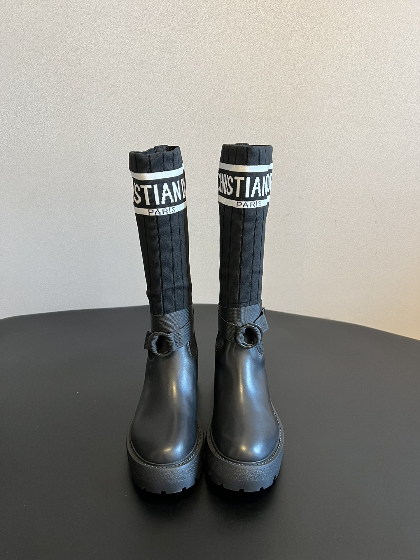 NO:615267,The top version of the Dior 25ss sock style stretch boots. The shoe body combines leather soles and knitted socks. The leather part is stiff and stylish, while the knitted socks add softness and elasticity, making it both handsome and comfortable. The eye-catching 'CHRISTIAN DIOR PARIS' white letter webbing is printed on the top of the socks to enhance brand recognition and become the visual focus of the look.  The boot body is equipped with buckle straps, which not only improves practicality, but also adds tough details of workwear style to the whole; the thick sole design has both a heightening effect and a retro texture. This boot style is highly versatile and can be flexibly combined with clothing and accessories according to different style needs, easily adapting to various scenes such as daily outings, parties or light workplaces. Upper cowhide/elastic socks Lining cowhide leather outsole original molded outsole increased by 8cm  size 35-40 (customized sizes 40 are non-refundable), boots, dior, boots, cowhide19860909顶级版本 Dior 25ss 袜靴款弹力长筒靴 鞋身结合了皮革靴底与针织袜筒,皮革部分挺括有型,针织袜筒则增添柔软弹性,兼具帅气与舒适感.袜筒上方印有醒目的“CHRISTIAN DIOR PARIS”白色字母织带,强化品牌辨识度,成为造型的视觉焦点. 靴身配有搭扣式绑带,既提升实用性,又为整体增添工装风的硬朗细节；厚底设计则兼具增高效果与复古质感.这款靴款的百搭性较强,可根据不同风格需求,灵活组合服饰与配饰,轻松适配日常出街、派对或轻职场等多种场景. 鞋面牛皮/弹力袜 内里牛皮 大底原版开模大底 增高8cm size35-40码（40码定制不退换）,靴子,dior,boots,cowhide,Women's Shoes