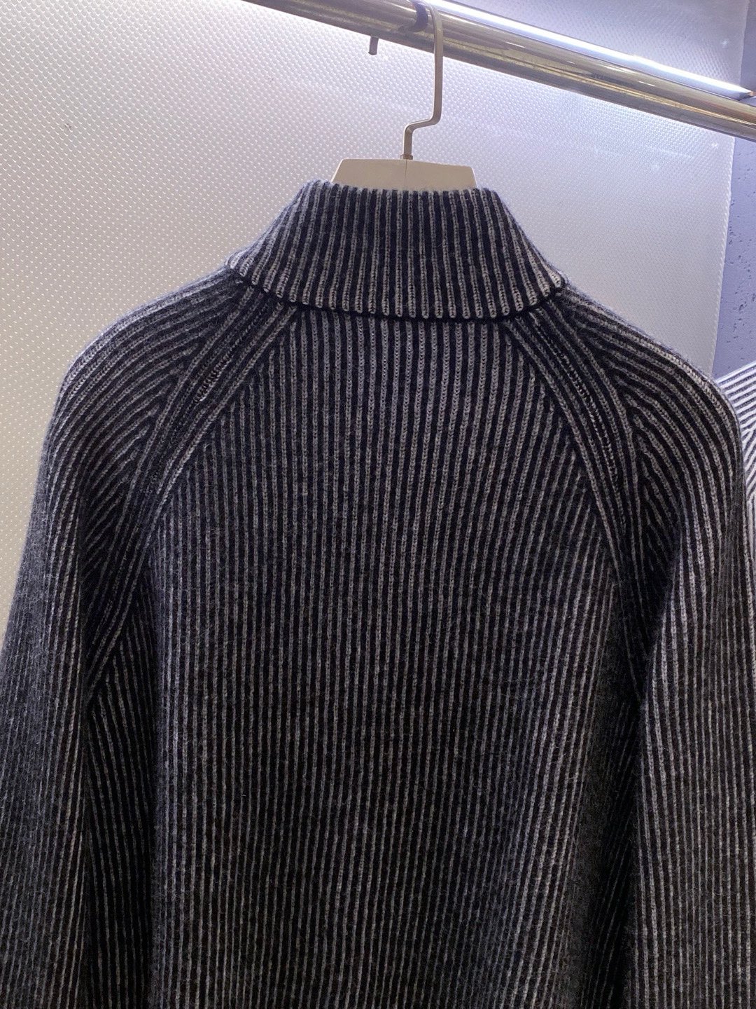 BC~半拉链叉肩袖男士坑条毛衣
秋冬新品～
精选100%花线羊毛织造，纱线自带细腻的色彩肌理，在光影下呈现柔和的渐变光泽，打破纯色羊毛衫的单调；坑条纹路纵向延伸，既赋予面料恰到好处的弹力，又悄然修饰身形，贴肤穿着无束缚感。以天然羊毛的温润为底，舒适温暖且无扎感。这款羊毛衫将舒适与设计感揉进每一寸针脚。
半拉链领口是点睛之笔，金属拉链头质感温润，可自由调节开合度&mdash;&mdash;拉至顶端，利落修饰颈部线条；微微下拉，露出内搭衣领，层次瞬间显现。叉肩袖设计弱化肩部线条，营造随性慵懒的松弛感，不挑肩型，适配各种身形。无论是搭配休闲裤漫步街头，还是内搭衬衫出入轻商务场合，都能以不经意的细节质感，诠释出不费力的时髦态度。

颜色：深灰色、浅灰色
规格：M--XXL
   P370
M码：叉肩袖长74、胸围110、衣长63
L码：叉肩袖长75、胸围114、衣长64