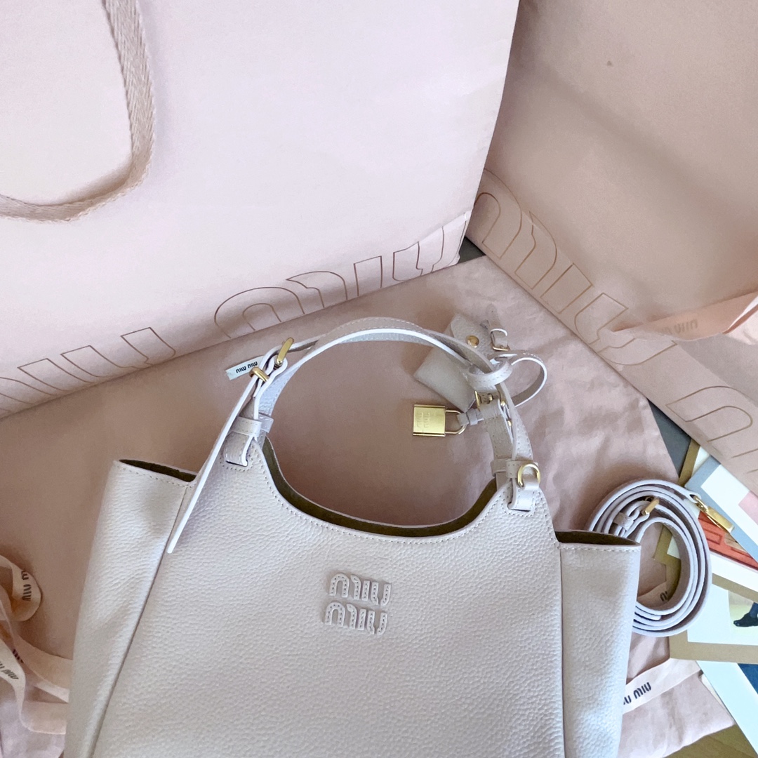 P850 5BA304:Miu家日本快闪新品托特包，顶级进口牛皮，皮面质感高级，优雅复古，包身软而不塌，搭配金属锁头挂件，气质随性慵懒，甜酷风格拉满，手工缝制皮面Logo标志，细节都很在线，通勤，逛街背都很适配，实用性MAX，
尺寸：25.5 X20 X13 cm