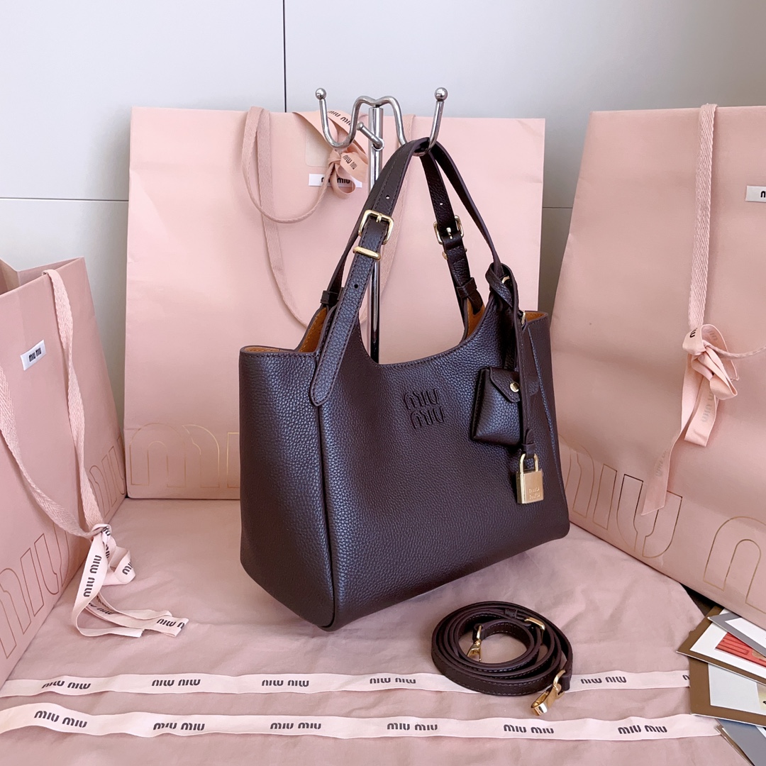 P850 5BA304:Miu家日本快闪新品托特包，顶级进口牛皮，皮面质感高级，优雅复古，包身软而不塌，搭配金属锁头挂件，气质随性慵懒，甜酷风格拉满，手工缝制皮面Logo标志，细节都很在线，通勤，逛街背都很适配，实用性MAX，
尺寸：25.5 X20 X13 cm