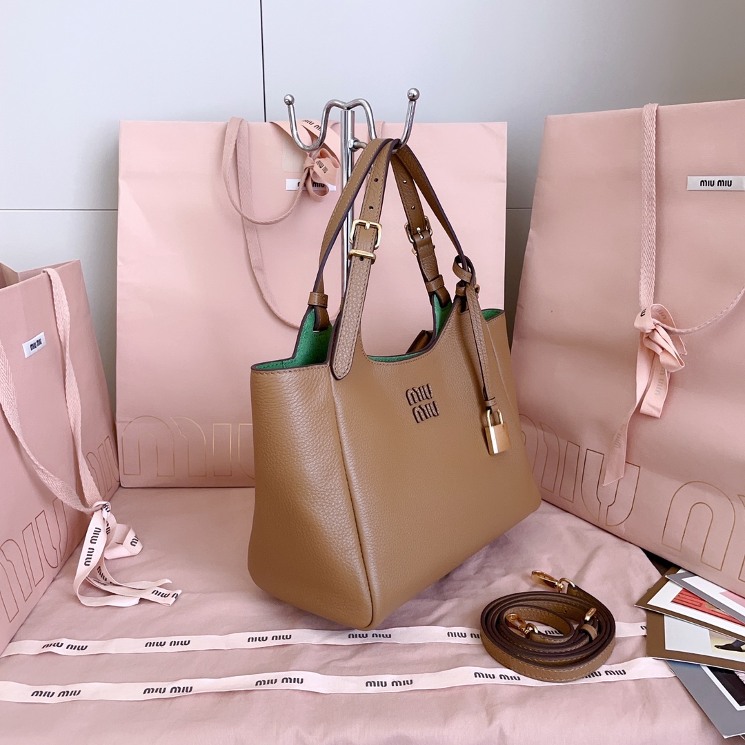 P850 5BA304:Miu家日本快闪新品托特包，顶级进口牛皮，皮面质感高级，优雅复古，包身软而不塌，搭配金属锁头挂件，气质随性慵懒，甜酷风格拉满，手工缝制皮面Logo标志，细节都很在线，通勤，逛街背都很适配，实用性MAX，
尺寸：25.5 X20 X13 cm