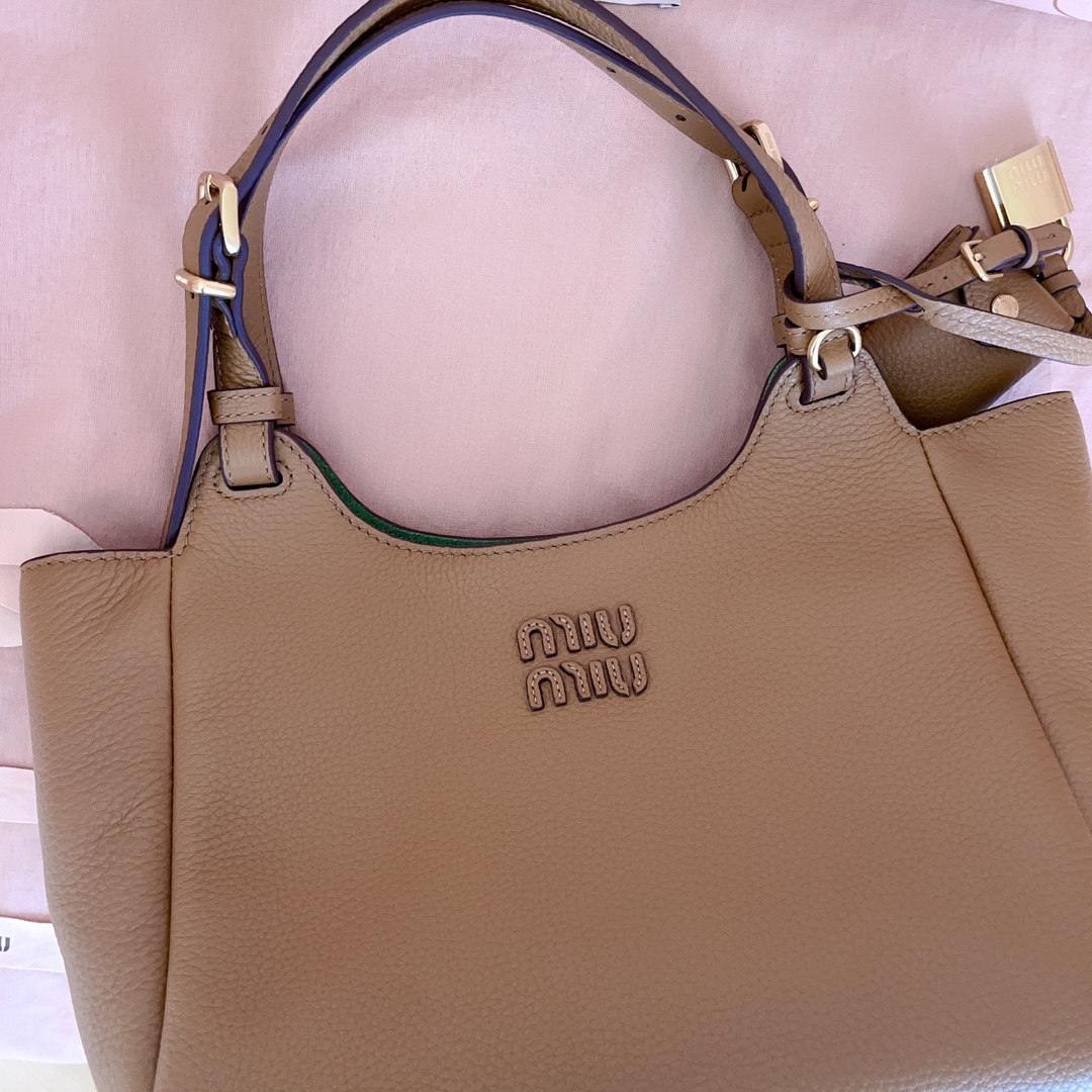 P850 5BA304:Miu家日本快闪新品托特包，顶级进口牛皮，皮面质感高级，优雅复古，包身软而不塌，搭配金属锁头挂件，气质随性慵懒，甜酷风格拉满，手工缝制皮面Logo标志，细节都很在线，通勤，逛街背都很适配，实用性MAX，
尺寸：25.5 X20 X13 cm