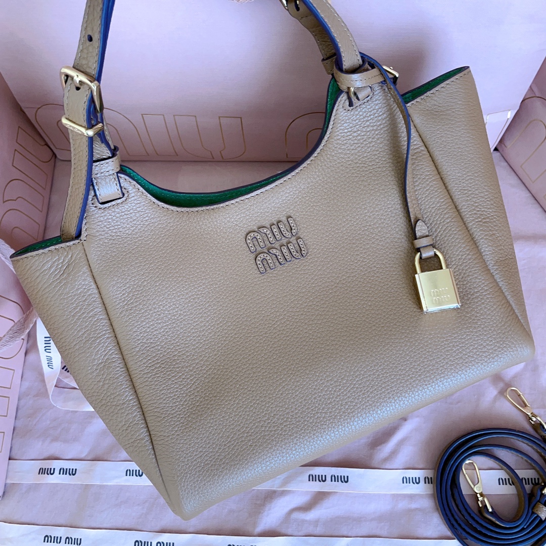 P850 5BA304:Miu家日本快闪新品托特包，顶级进口牛皮，皮面质感高级，优雅复古，包身软而不塌，搭配金属锁头挂件，气质随性慵懒，甜酷风格拉满，手工缝制皮面Logo标志，细节都很在线，通勤，逛街背都很适配，实用性MAX，
尺寸：25.5 X20 X13 cm