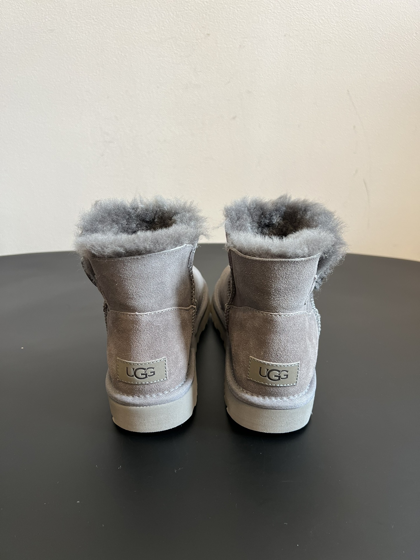 UG* 秋冬保暖圆扣logo短款雪地靴采用羊皮毛一体材质，鞋面是质感细腻的反绒皮，内里填充柔软的羊毛，既