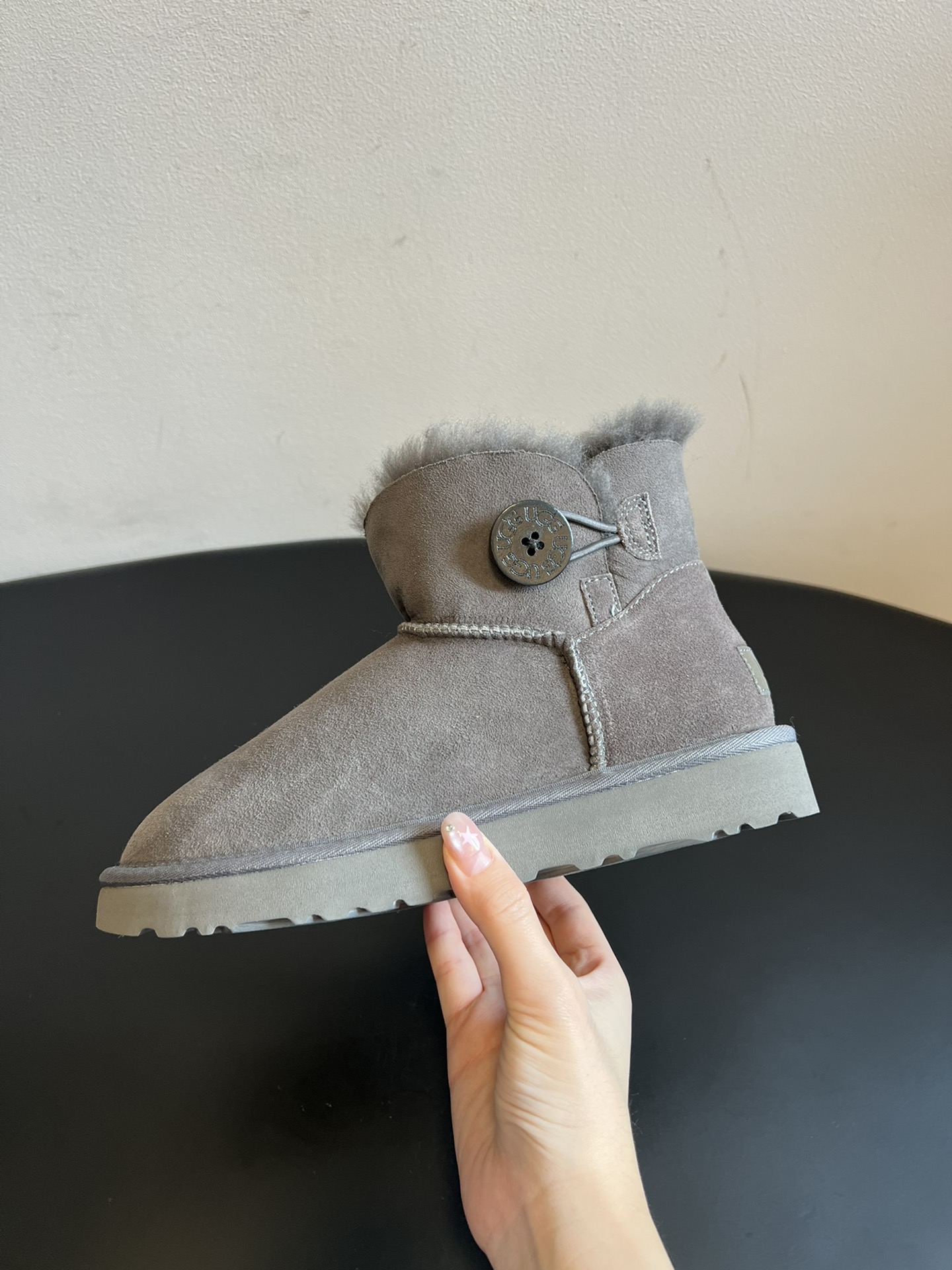 UG* 秋冬保暖圆扣logo短款雪地靴采用羊皮毛一体材质，鞋面是质感细腻的反绒皮，内里填充柔软的羊毛，既