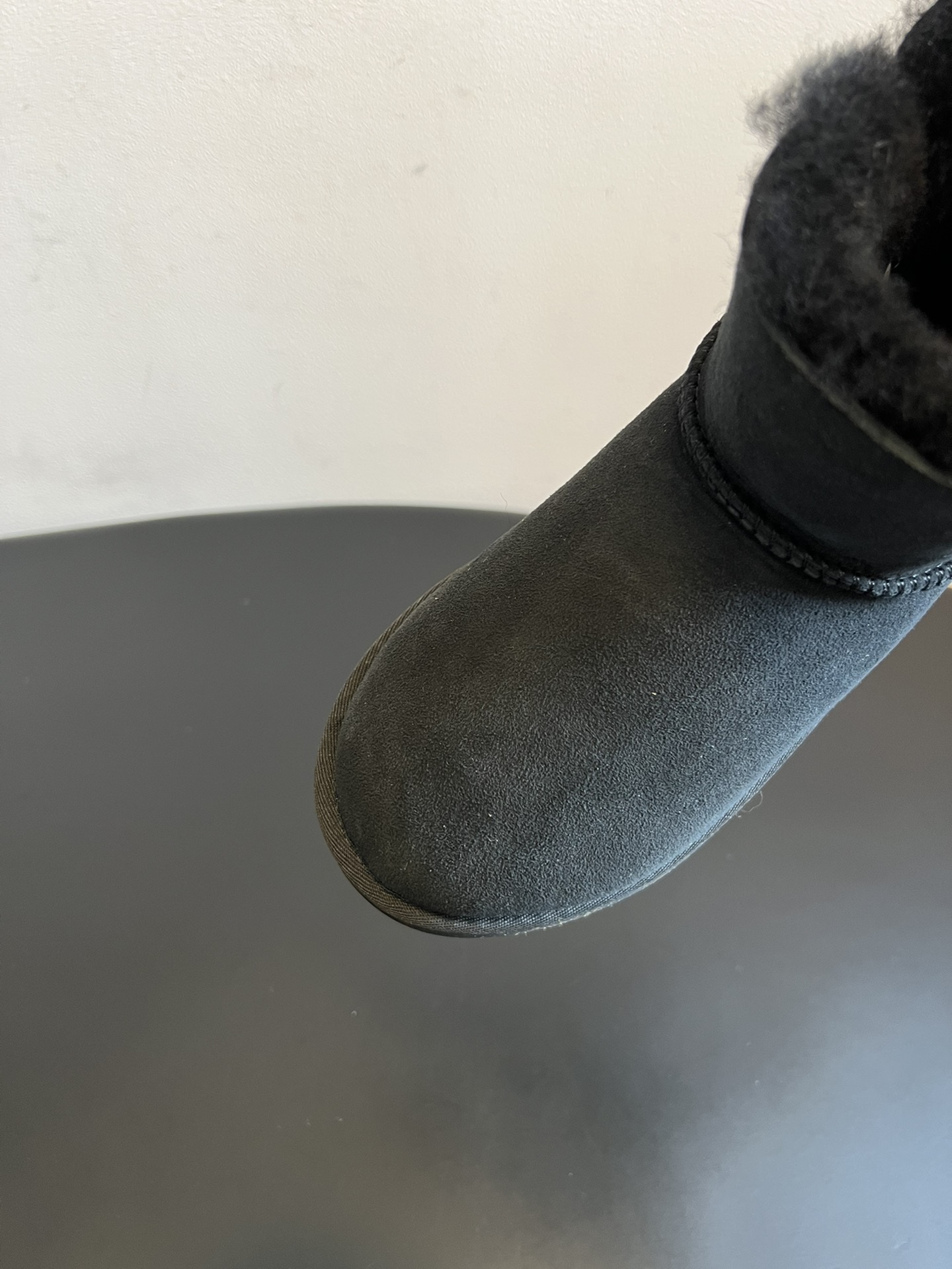 UG* 秋冬保暖圆扣logo短款雪地靴采用羊皮毛一体材质，鞋面是质感细腻的反绒皮，内里填充柔软的羊毛，既