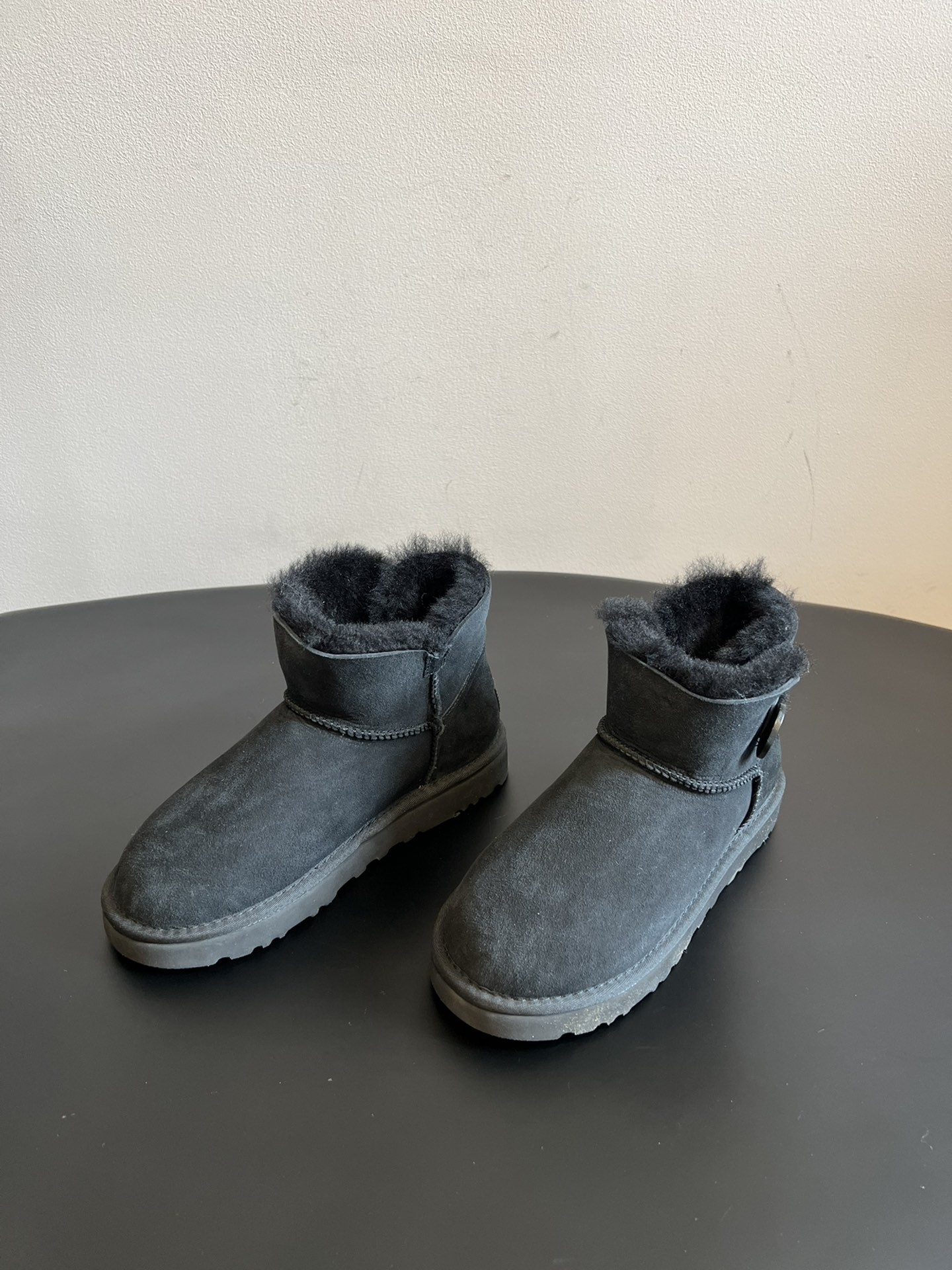 UG* 秋冬保暖圆扣logo短款雪地靴采用羊皮毛一体材质，鞋面是质感细腻的反绒皮，内里填充柔软的羊毛，既