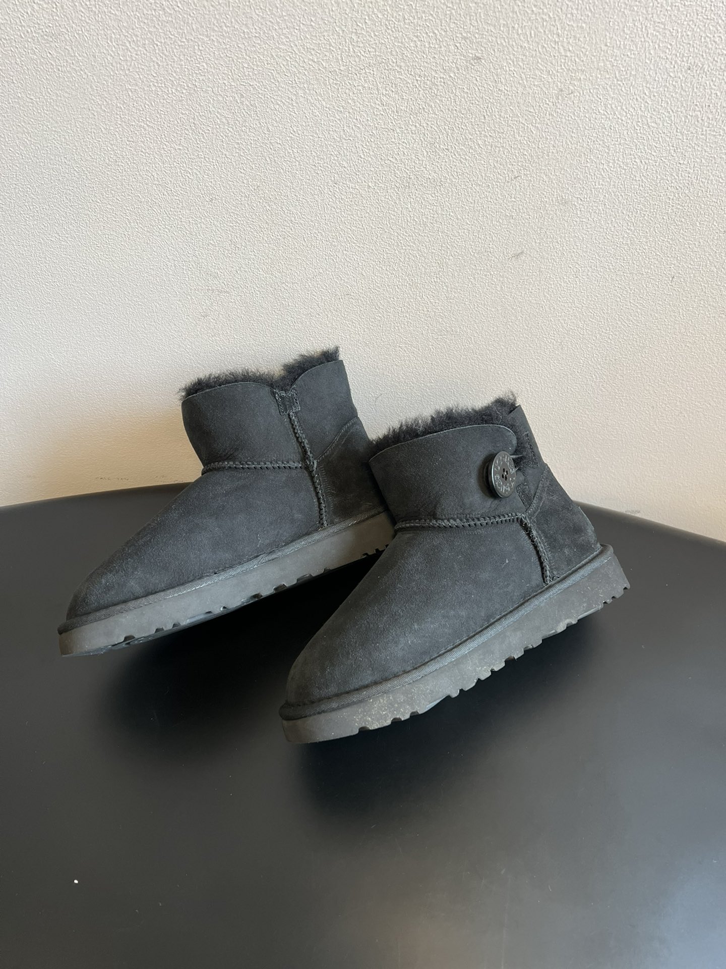 UG* 秋冬保暖圆扣logo短款雪地靴采用羊皮毛一体材质，鞋面是质感细腻的反绒皮，内里填充柔软的羊毛，既