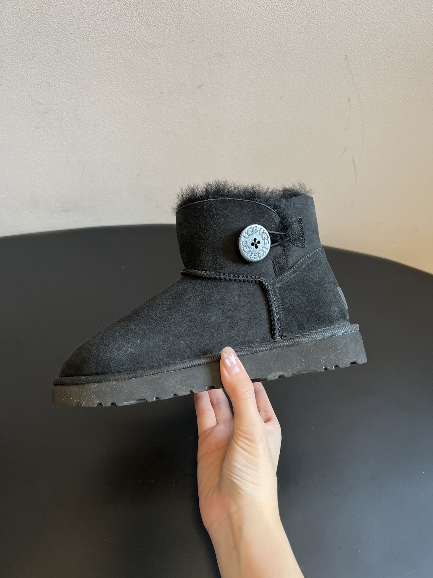 UG* 秋冬保暖圆扣logo短款雪地靴采用羊皮毛一体材质，鞋面是质感细腻的反绒皮，内里填充柔软的羊毛，既