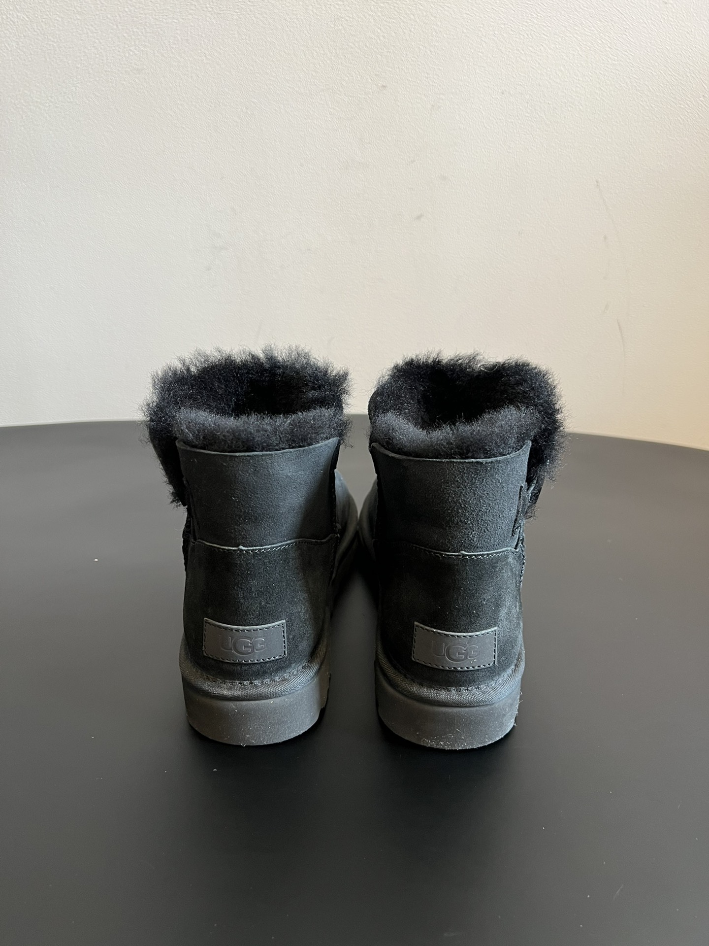 UG* 秋冬保暖圆扣logo短款雪地靴采用羊皮毛一体材质，鞋面是质感细腻的反绒皮，内里填充柔软的羊毛，既