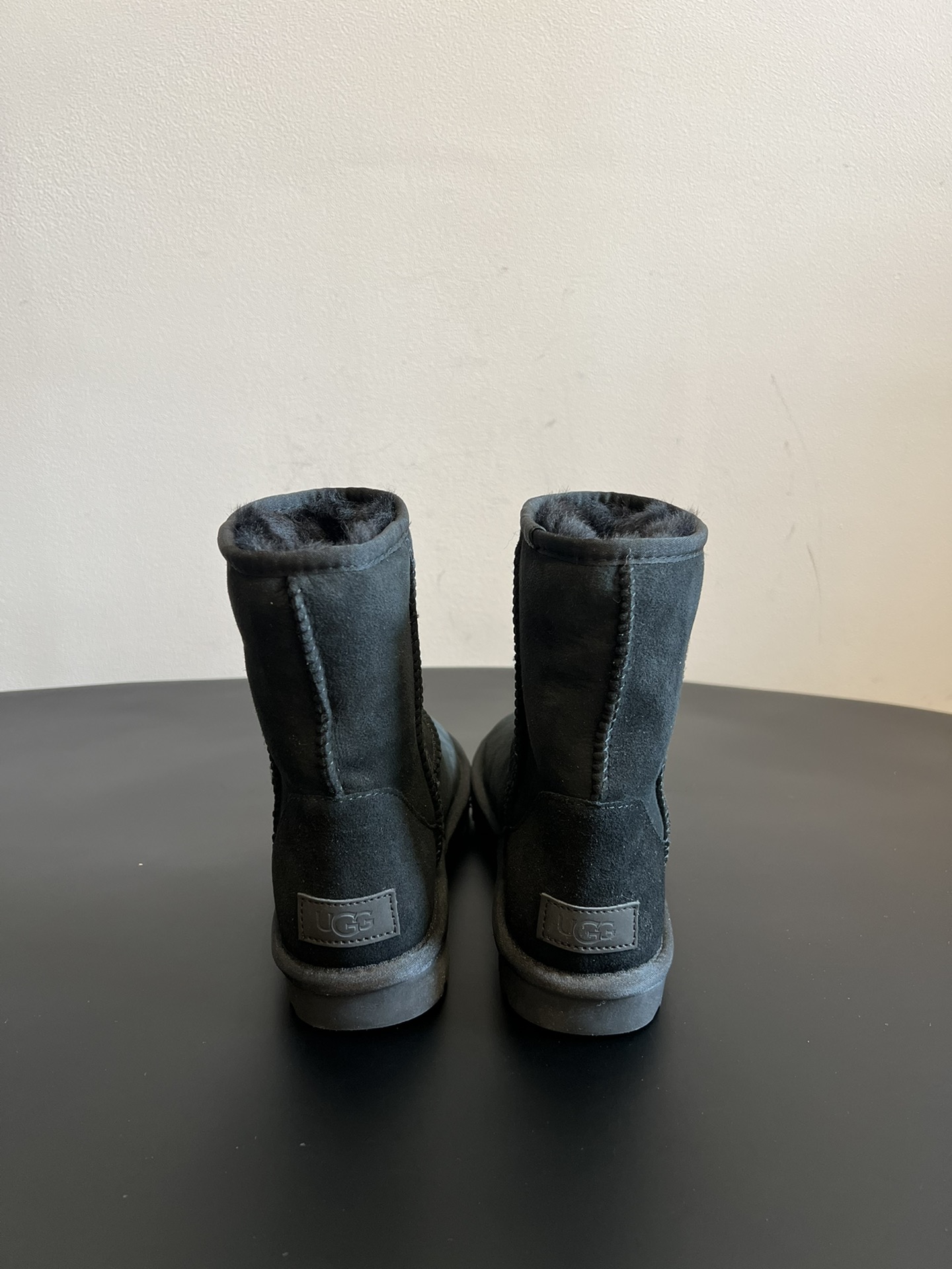 UG* 秋冬保暖圆头雪地靴鞋面采用翻毛皮材质，内里填充羊毛，实现保暖与质感的结合。中筒靴型搭配侧边扣带设