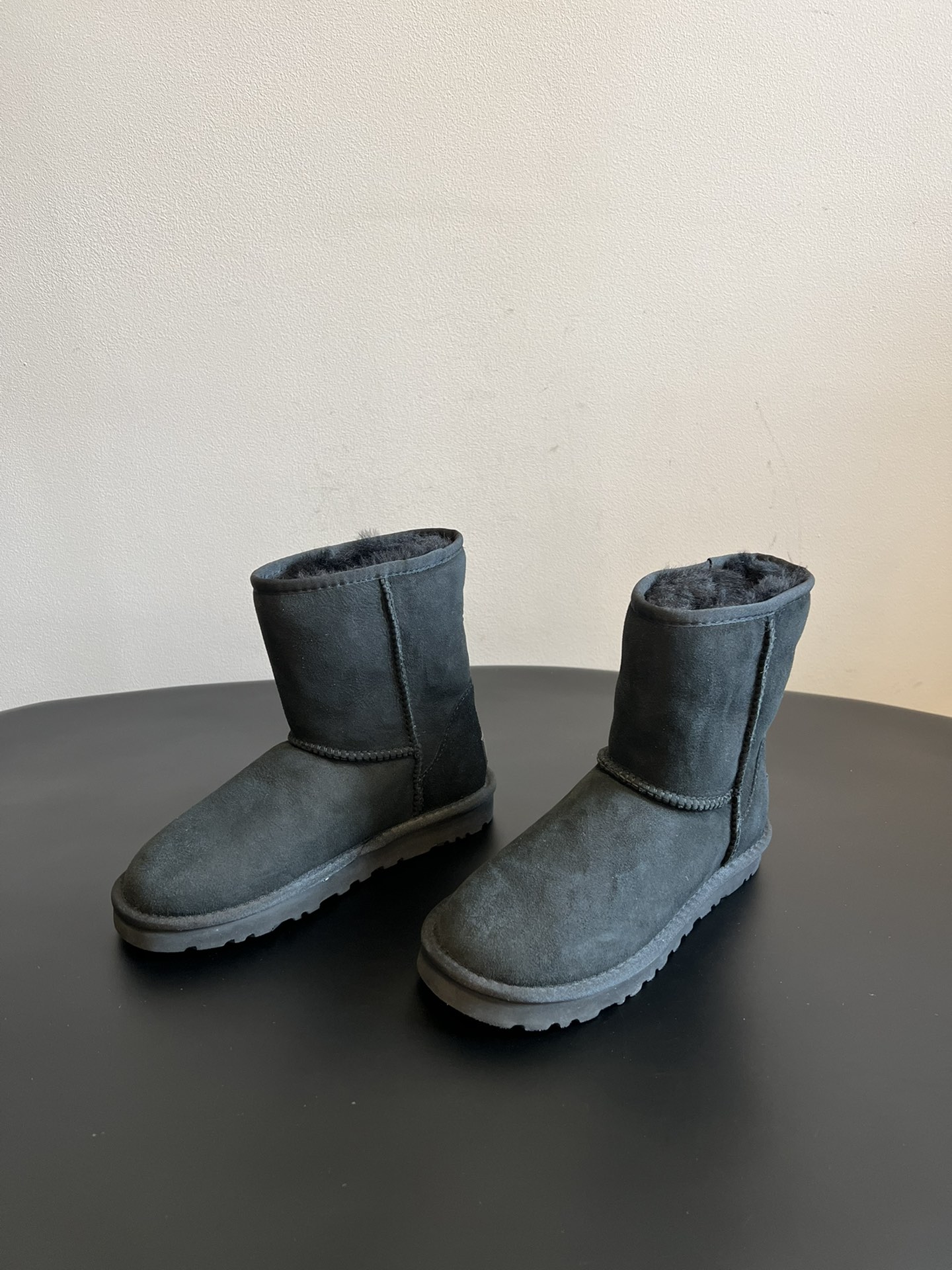 UG* 秋冬保暖圆头雪地靴鞋面采用翻毛皮材质，内里填充羊毛，实现保暖与质感的结合。中筒靴型搭配侧边扣带设