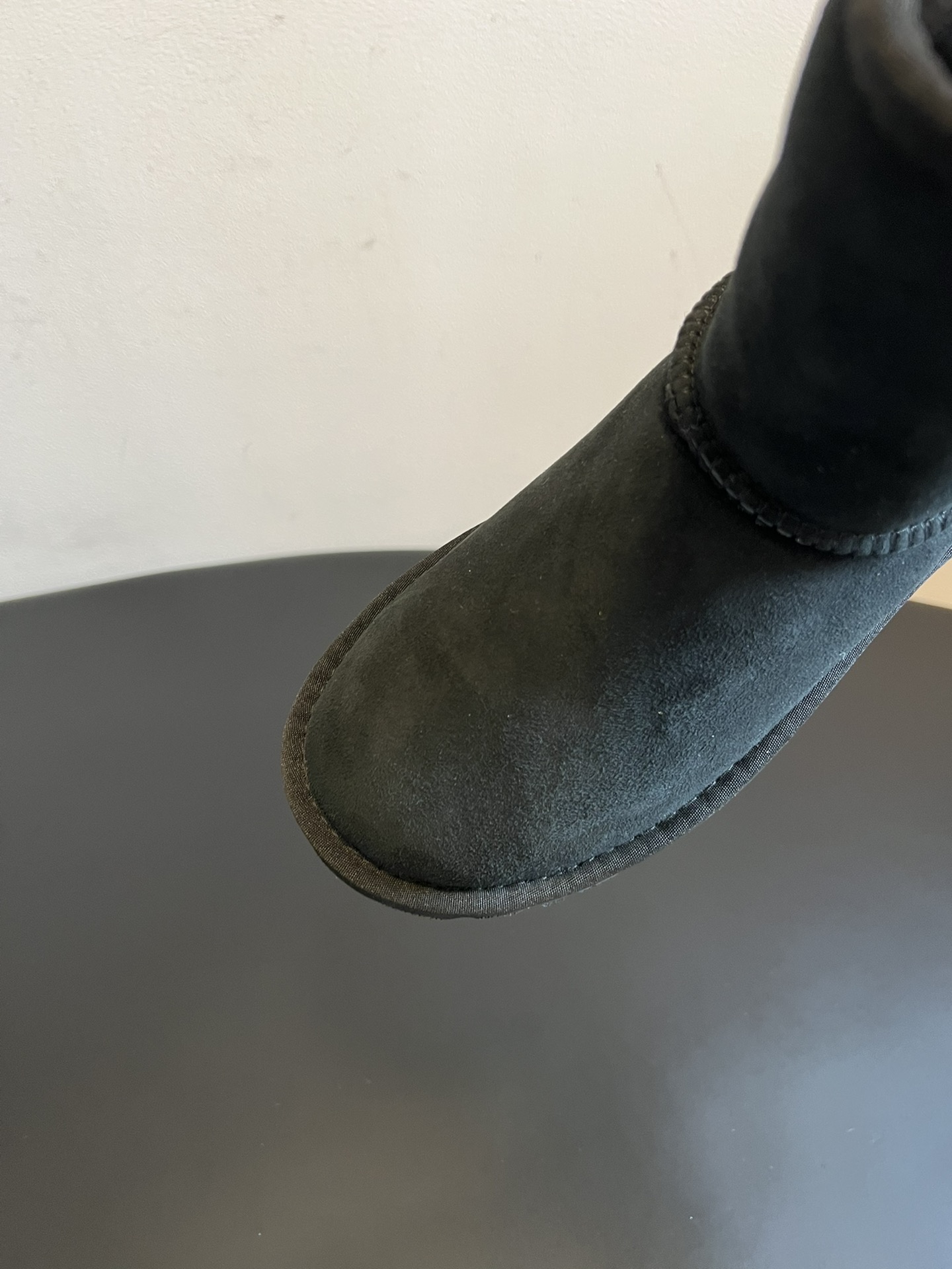 UG* 秋冬保暖圆头雪地靴鞋面采用翻毛皮材质，内里填充羊毛，实现保暖与质感的结合。中筒靴型搭配侧边扣带设