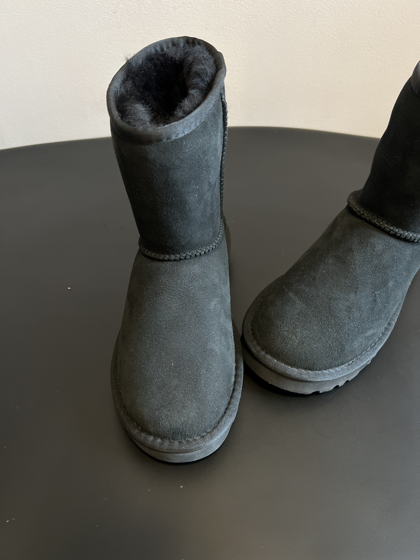 UG* 秋冬保暖圆头雪地靴鞋面采用翻毛皮材质，内里填充羊毛，实现保暖与质感的结合。中筒靴型搭配侧边扣带设