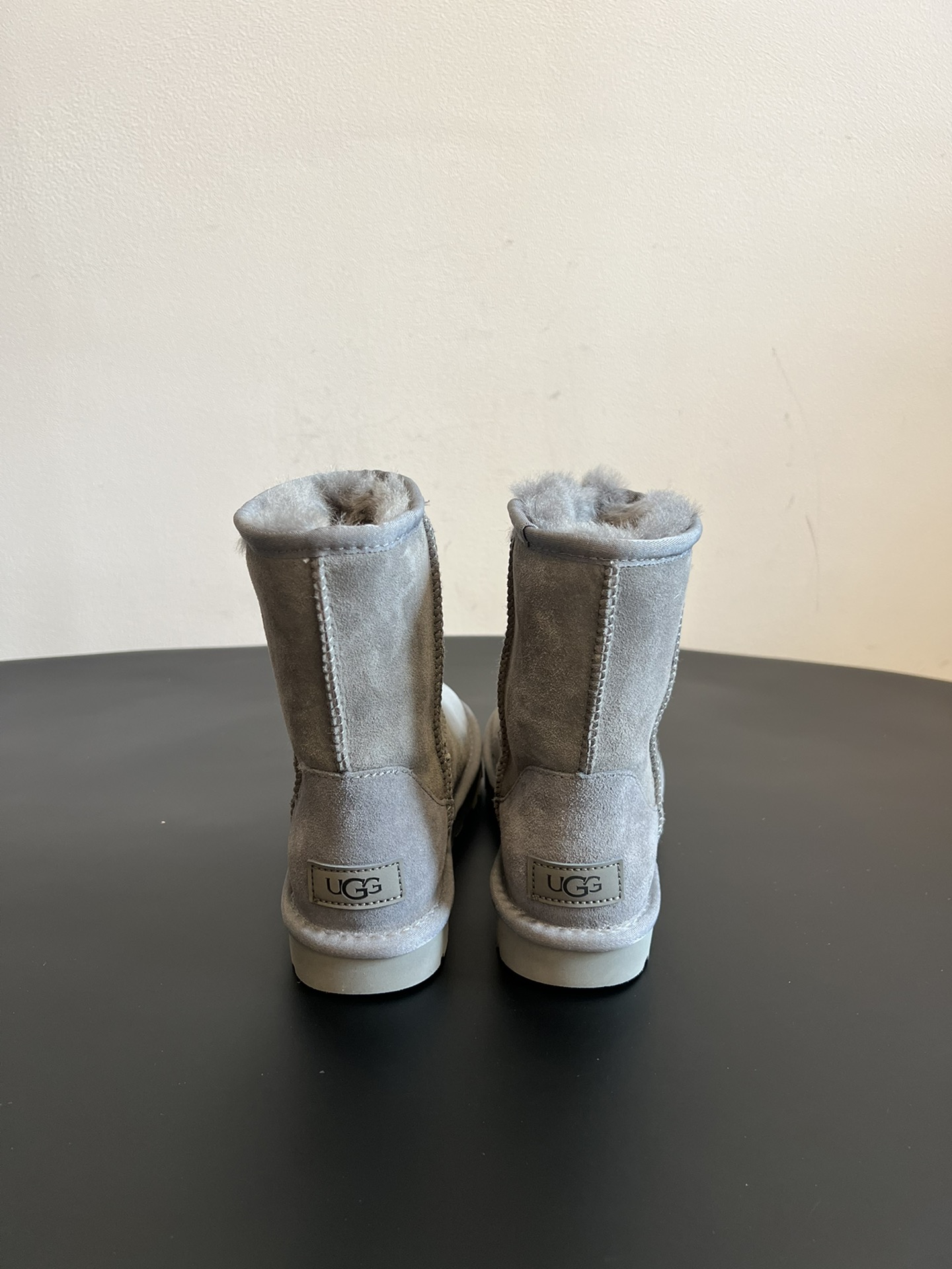 UG* 秋冬保暖圆头雪地靴鞋面采用翻毛皮材质，内里填充羊毛，实现保暖与质感的结合。中筒靴型搭配侧边扣带设