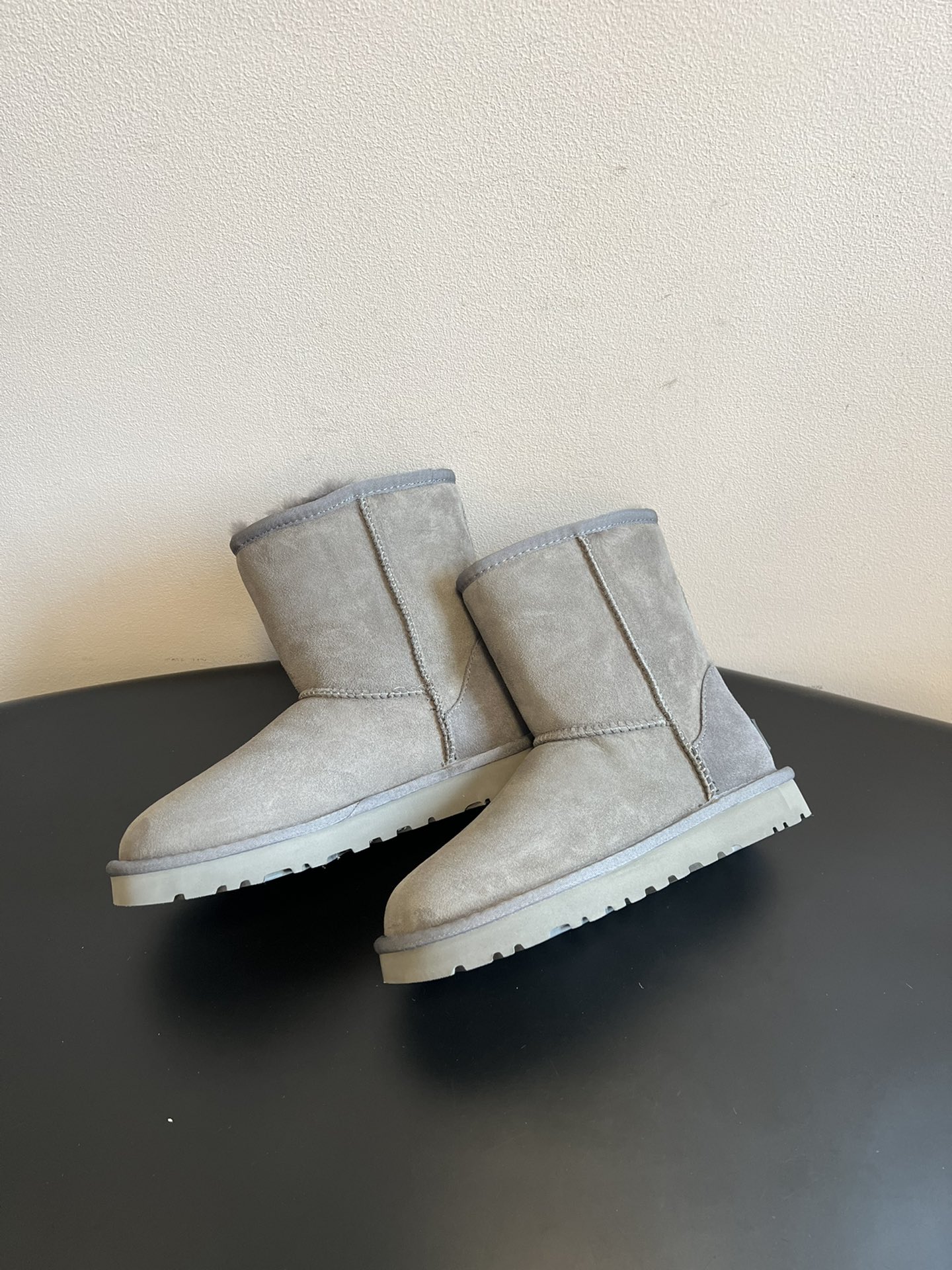 UG* 秋冬保暖圆头雪地靴鞋面采用翻毛皮材质，内里填充羊毛，实现保暖与质感的结合。中筒靴型搭配侧边扣带设