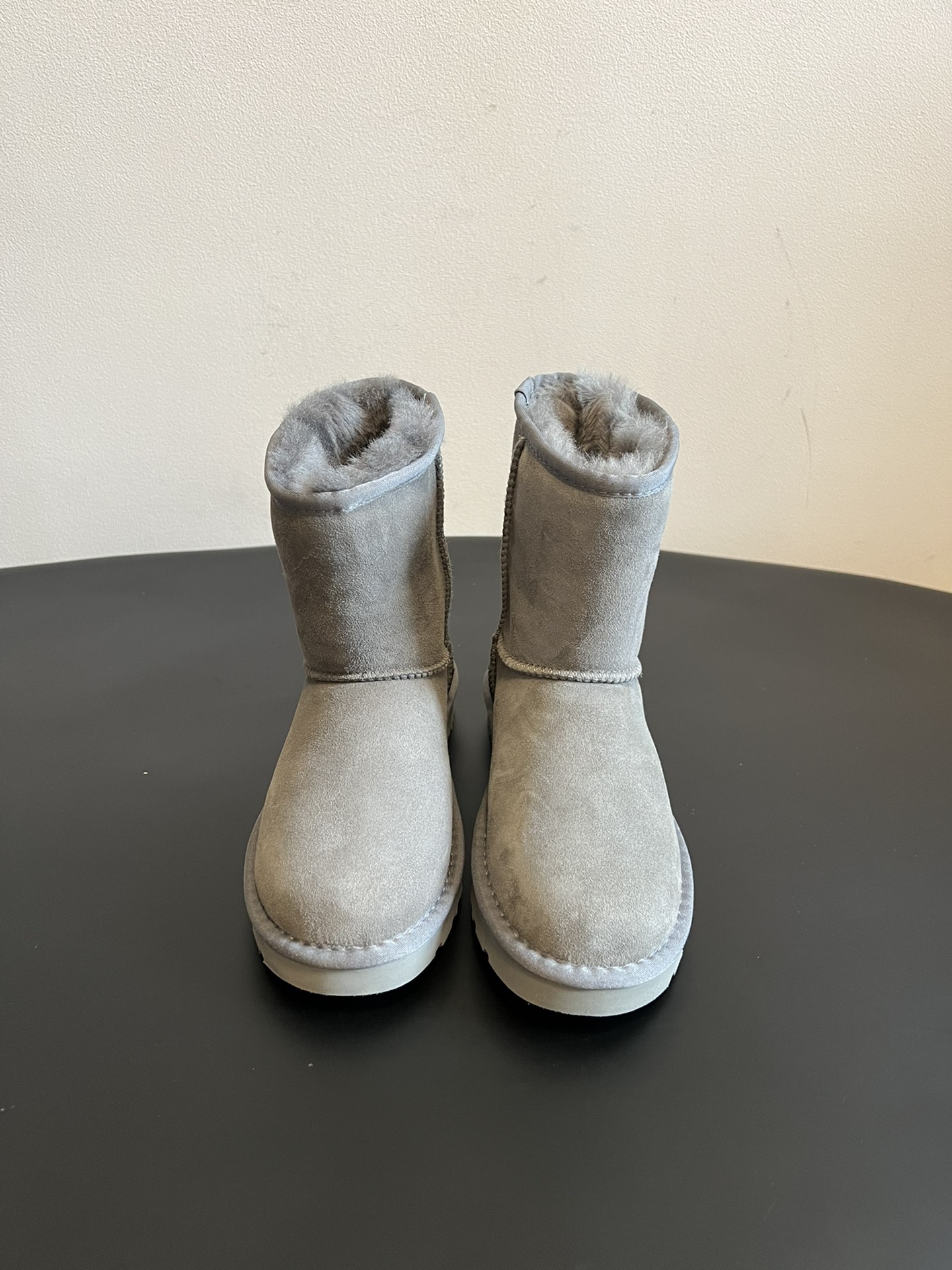 UG* 秋冬保暖圆头雪地靴鞋面采用翻毛皮材质，内里填充羊毛，实现保暖与质感的结合。中筒靴型搭配侧边扣带设