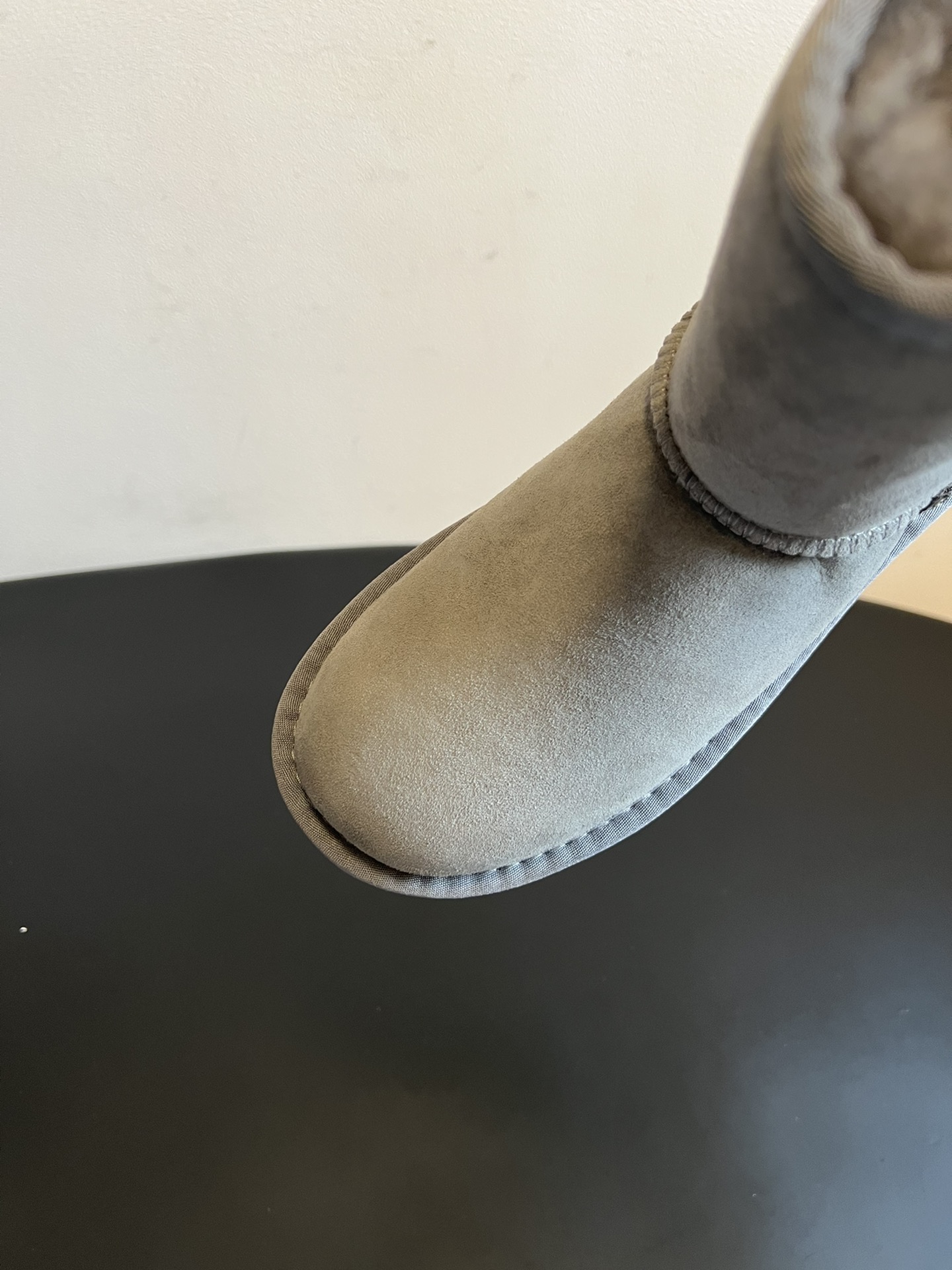 UG* 秋冬保暖圆头雪地靴鞋面采用翻毛皮材质，内里填充羊毛，实现保暖与质感的结合。中筒靴型搭配侧边扣带设