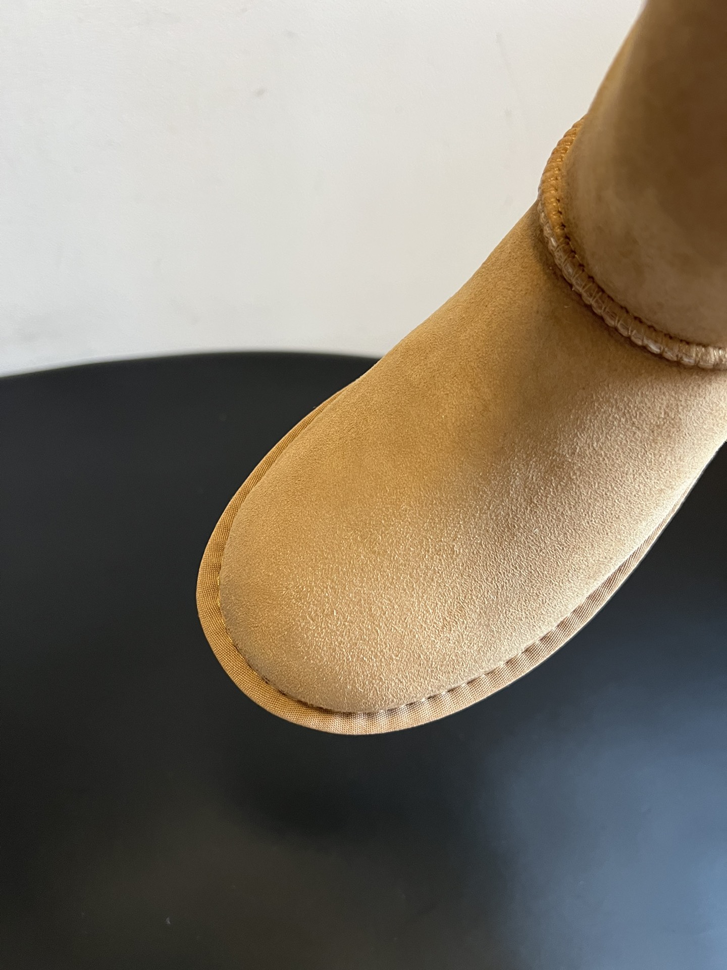 UG* 秋冬保暖圆头雪地靴鞋面采用翻毛皮材质，内里填充羊毛，实现保暖与质感的结合。中筒靴型搭配侧边扣带设