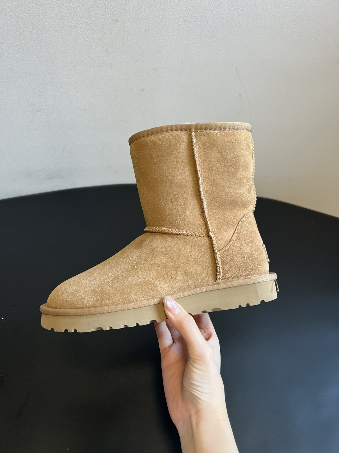 UG* 秋冬保暖圆头雪地靴鞋面采用翻毛皮材质，内里填充羊毛，实现保暖与质感的结合。中筒靴型搭配侧边扣带设