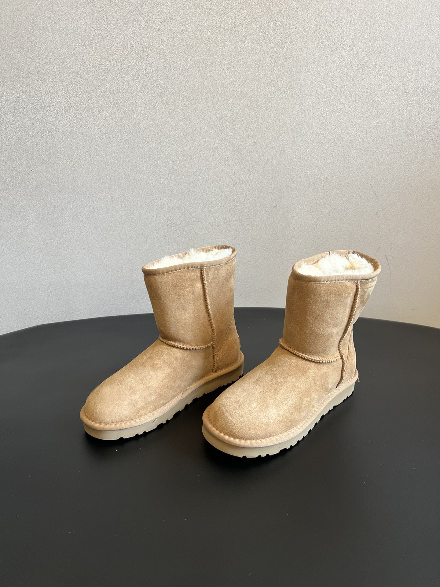 UG* 秋冬保暖圆头雪地靴鞋面采用翻毛皮材质，内里填充羊毛，实现保暖与质感的结合。中筒靴型搭配侧边扣带设