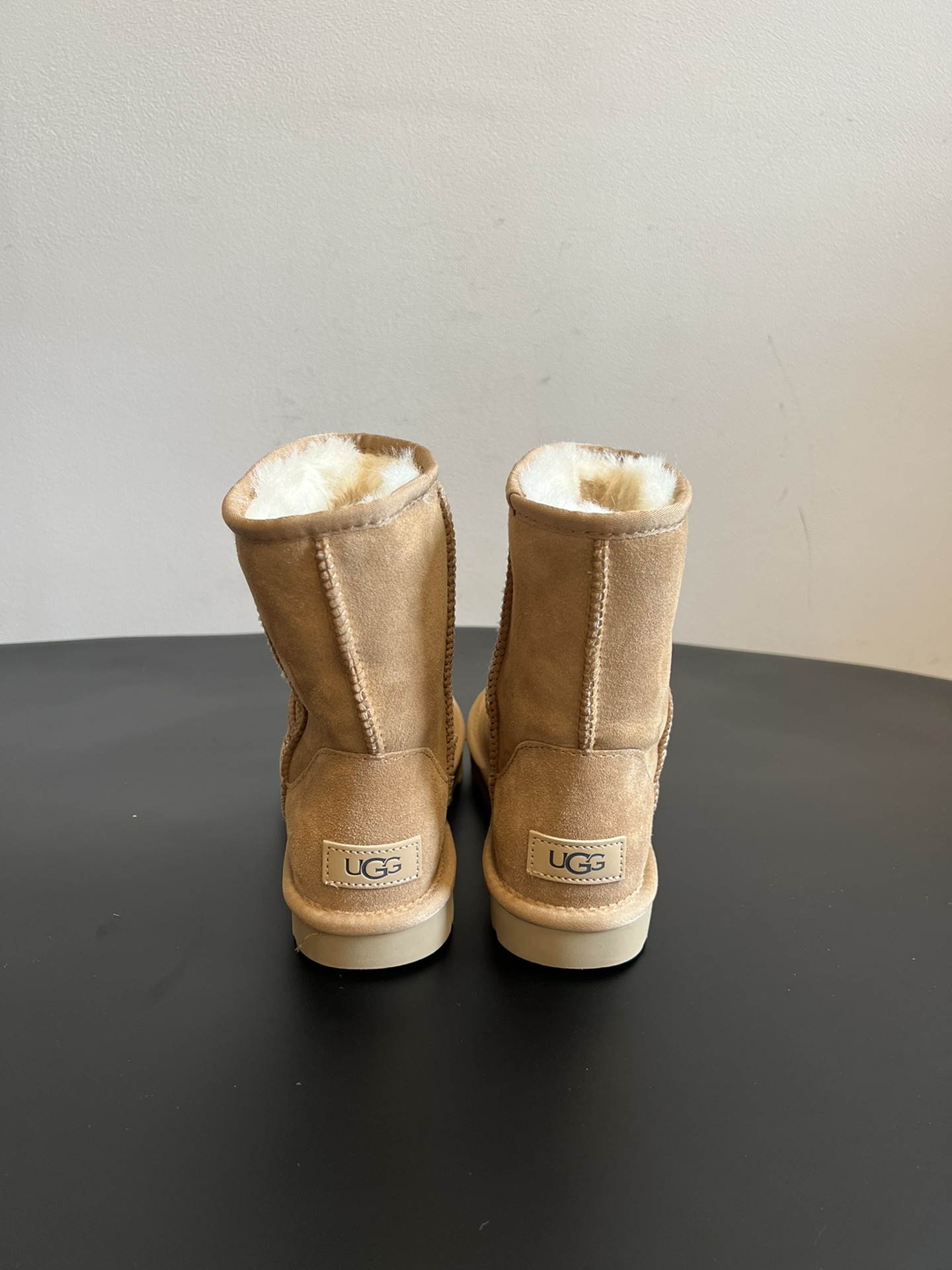 UG* 秋冬保暖圆头雪地靴鞋面采用翻毛皮材质，内里填充羊毛，实现保暖与质感的结合。中筒靴型搭配侧边扣带设