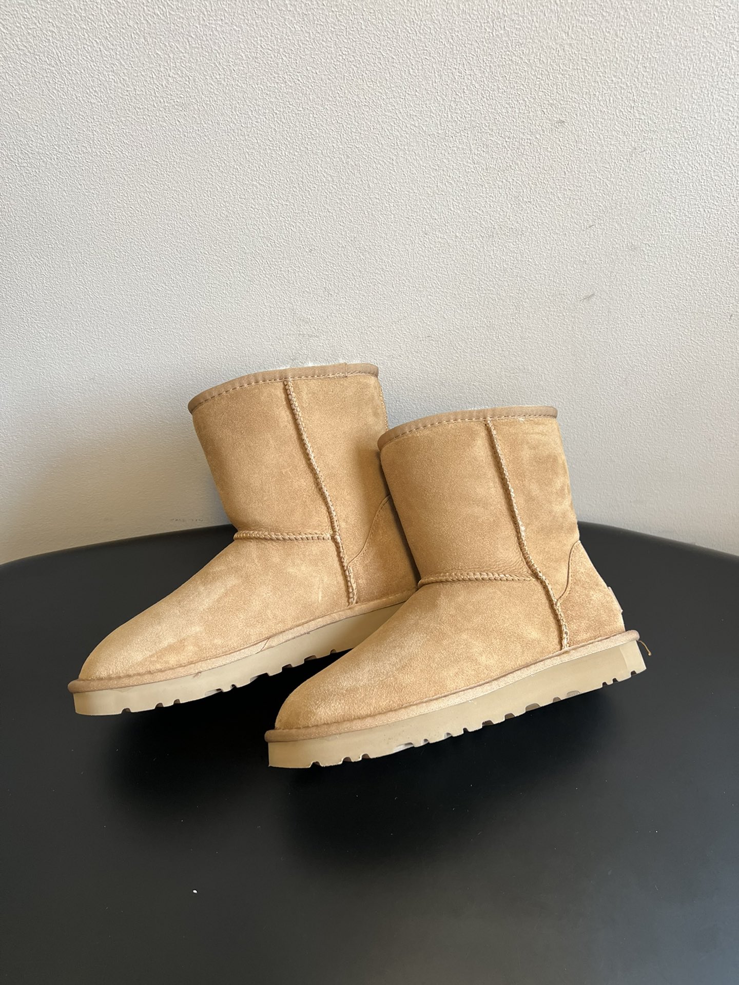 UG* 秋冬保暖圆头雪地靴鞋面采用翻毛皮材质，内里填充羊毛，实现保暖与质感的结合。中筒靴型搭配侧边扣带设