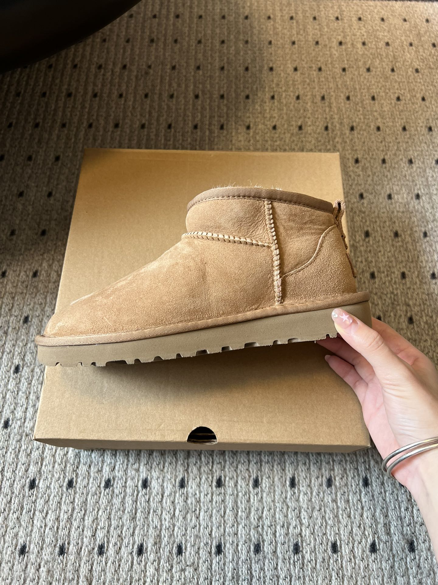 UG* 秋冬保暖mini款雪地靴采用羊皮毛一体材质，鞋面是质感细腻的反绒皮，内里填充柔软的羊毛，既保暖又