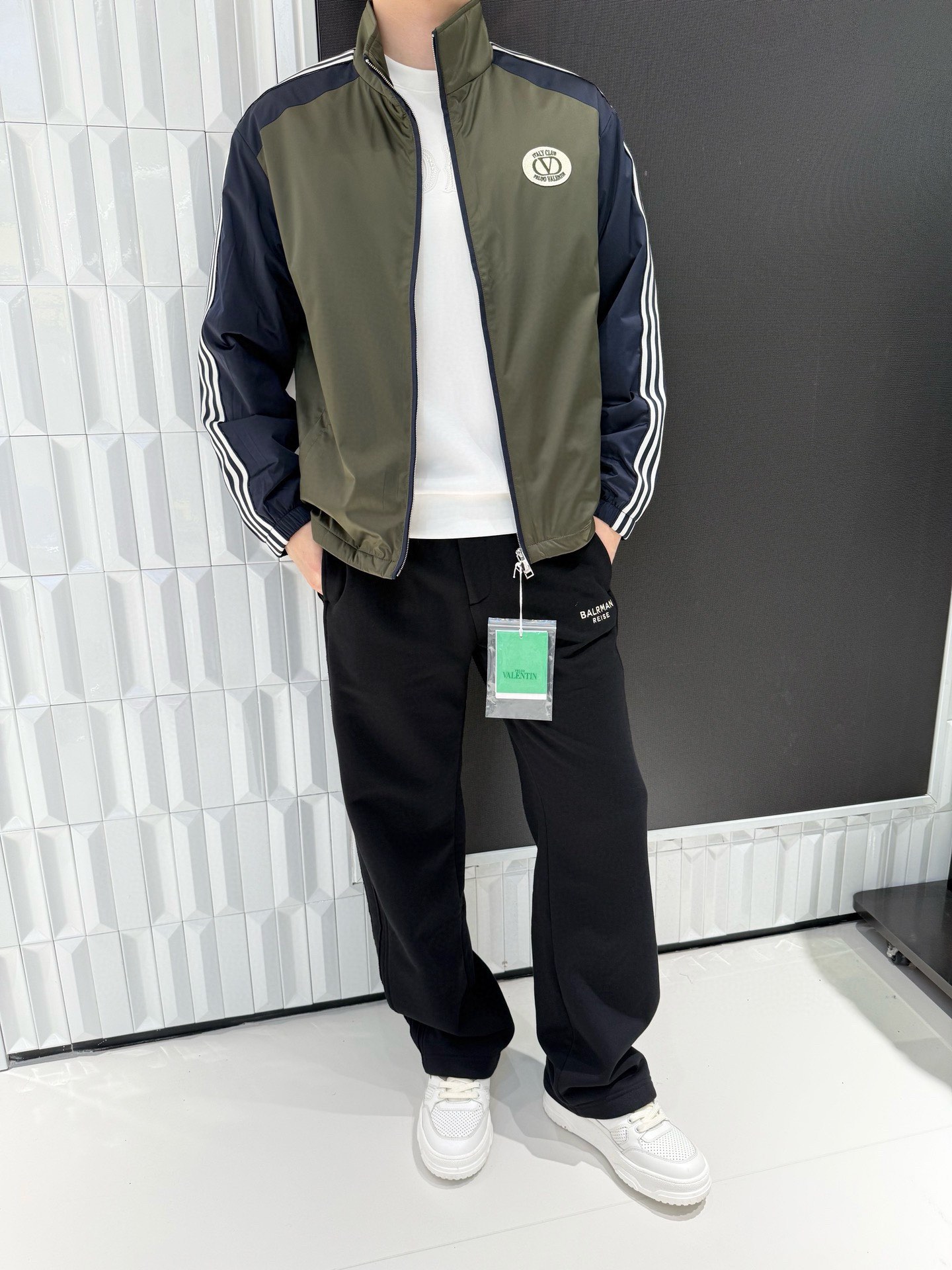 NO:595146,Valentino - high-end new jacket!  Contrasting color splicing (olive green main body + navy blue sleeves) creates visual hierarchy. The white stripes on the sleeve sides echo the brand badge on the chest, restoring the classic tone of the retro sports jacket, with both a sense of trend and a nostalgic atmosphere. The use of light and windproof high-density fabric can effectively block the light cold wind in spring and autumn, while maintaining the lightness of wearing without being heavy.  It has a sense of restraint and more freedom of movement. The zipper collar design is easy to put on and take off, easily creating a 'layered layering', and the retro sports style is suitable for leisure, street and other diverse styling scenes. Size: 50-56 (model 180/140 wears 50, with Hong Kong Lane Crawford gift box packaging),, valentino, jackets  & coats,alexander wang19860909华伦天奴-高端新款外套！撞色拼接（橄榄绿主身+藏青袖身）打造视觉层次,袖侧白色条纹与胸前品牌徽章相呼应,还原复古运动外套的经典调性,兼具潮流感与怀旧氛围.选用轻薄防风的高密面料,能有效阻隔春秋季的轻量寒风,同时保持穿着的轻盈度,无厚重束缚感,活动更自由.领拉链设计便捷穿脱,轻松打造“叠穿层次感”,复古运动风格适配休闲、街头等多元造型场景.码数:50-56(模特180/140穿50,配香港连卡佛礼盒包装),,valentino,jackets & coats,alexander wang,Men's clothing