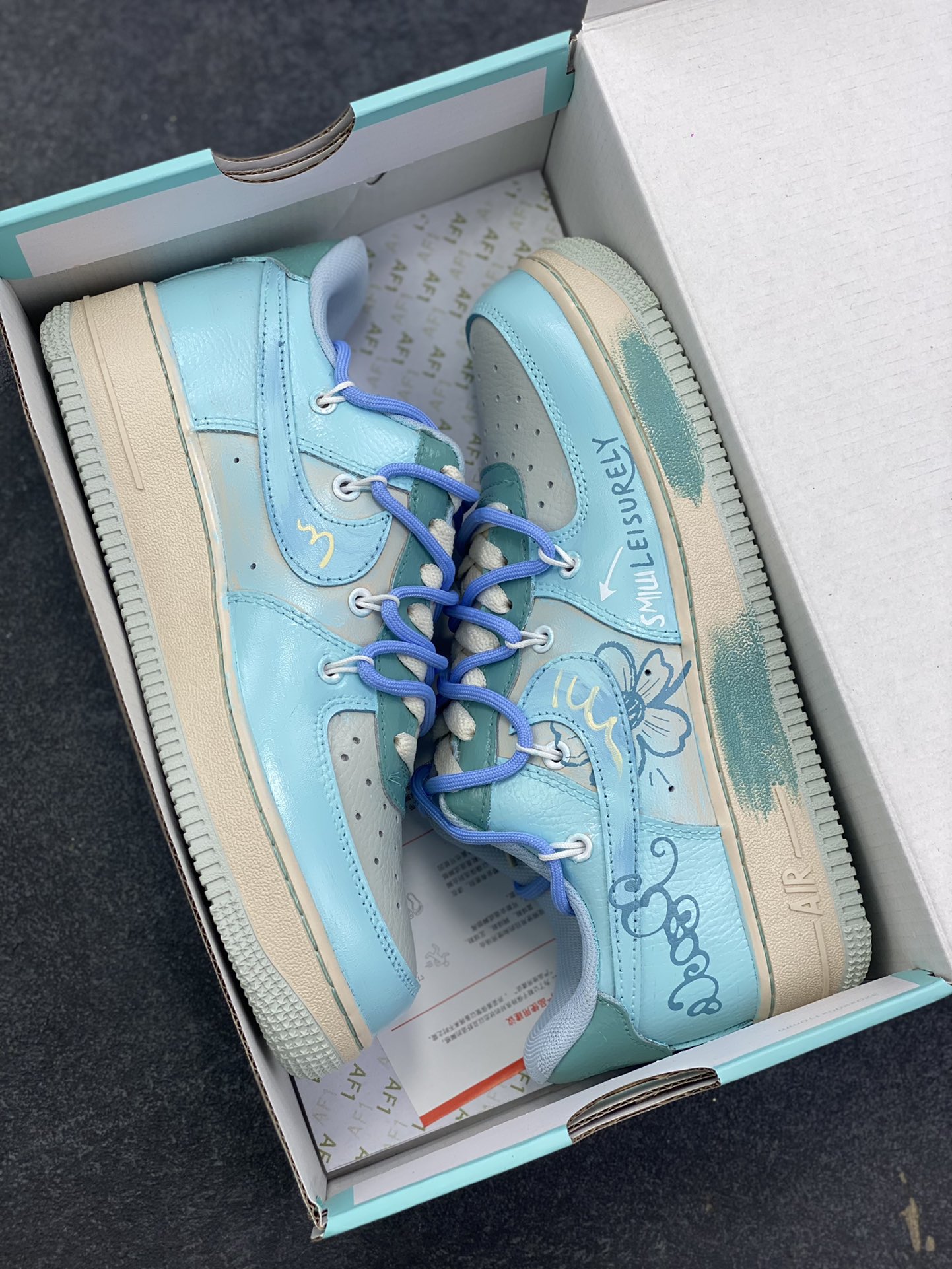 图片[9]-手绘涂鸦“青空花屿”Nike Air Force 1 “Qingkong ”空军一号定制板鞋 浅蓝主调如澄澈青空，将夏日的明朗与松弛感晕染其上；手绘花卉似岛屿繁花，在鞋身肆意生长，把自然的烂漫与随性娓娓道来。“LEISURELY”字样更是点睛之笔，直白地宣告着它的设计内核——以闲趣为衣，以自在为裳 货号：KS6968-777 尺码：36 36.5 37.5 38 38.5 39 40 40.5 41 42 42.5 43 44 44.5 45-选品中心