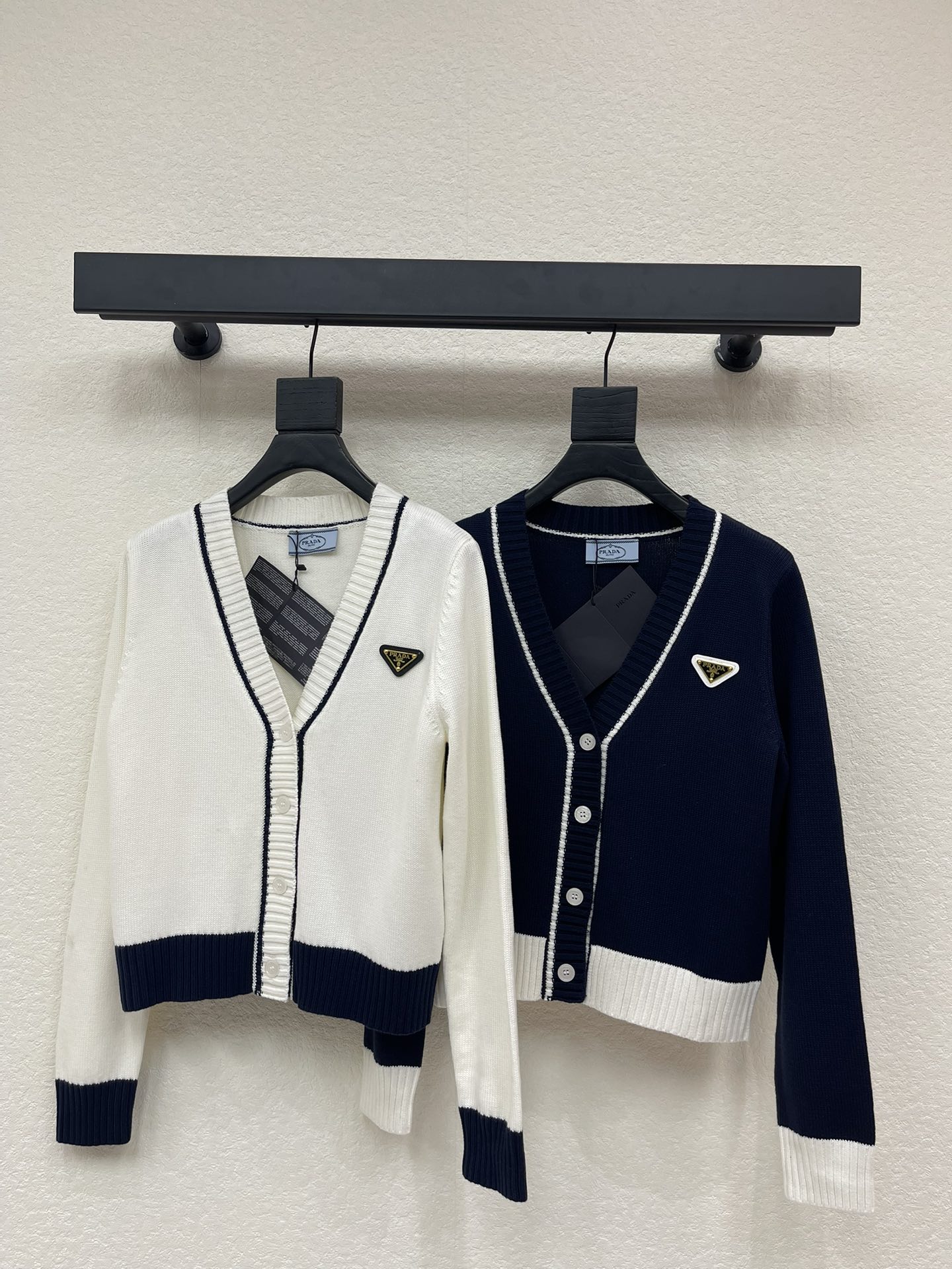 NO:587923,Prad*25 new autumn and winter new hemmed contrasting color knitted cardigan. Customized YB cotton yarn weaving, fine texture, comfortable to wear, V-neck knitted cardigan version, ready-to-wear buttons decorate the placket, narrowed by elastic pit thread hemming, the collar extends to the front placket with striped cuffs and brick red threads at the hem, triangle logo letters on the chest are decorated, the overall shape is advanced and casual, colliding with fashion tones, creating a brand-specific and sometimes fashionable style. SML  A,,prada,alexander wang19860909Prad*25秋冬新款包边撞色针织开衫.定制YB全棉纱线织造,质感细腻,穿搭舒适,V领针织开衫版型,成衣纽扣装饰开襟,以弹力坑条螺纹包边收窄,领边延伸至前襟条纹袖口下摆砖红色螺纹,胸前三角徽标字母装饰,整体造型高级休闲,碰撞出时尚调性,打造品牌特有时时髦风格.SML A,,prada,alexander wang,Women's clothing