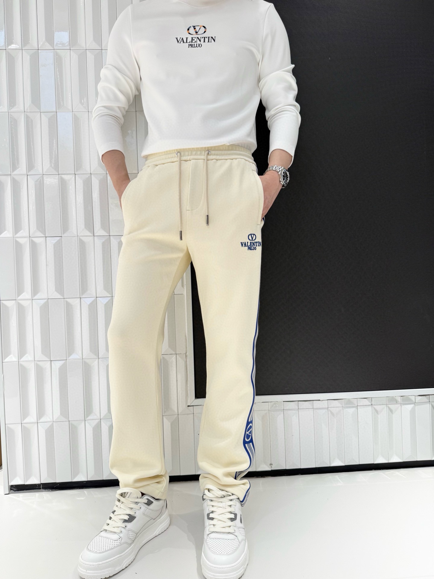 NO:595059,Valentino-2025 high-end new casual pants!  Made of high-quality skin-friendly fabrics, soft and delicate, with good breathability and warmth, it can maintain a comfortable feel even if worn for a long time, and is not easy to deform or pill, and is durable. The main tone of off-white is simple and elegant, and the blue and white stripe splicing design on the side is very dynamic and recognizable. The brand 'VALENTIN'  PRUJO' embroidery is exquisite, highlighting quality; the drawstring waist design can be freely adjusted to fit different waistlines, and the straight version modifies the leg shape, creating a casual and trendy style. Size: 48-56 (model 180/140 wears 50, with Hong Kong Lane Crawford gift box packaging),, valentino, valentino, alexander wang19860909华伦天奴-2025高端新款休闲裤！采用优质亲肤面料,柔软细腻,具有良好的透气性与保暖性,长时间穿着也能保持舒适体感,且不易变形、起球,经久耐穿.米白色主调简约大气,侧边蓝白条纹拼接设计极具动感与辨识度,品牌“VALENTIN PRUJO”刺绣精致,彰显品质；抽绳腰头设计可自由调节松紧,适配不同腰围,直筒版型修饰腿型,打造随性潮流的穿搭风格.码数:48-56(模特180/140穿50,配香港连卡佛礼盒包装),,valentino,valentino,alexander wang,Men's clothing