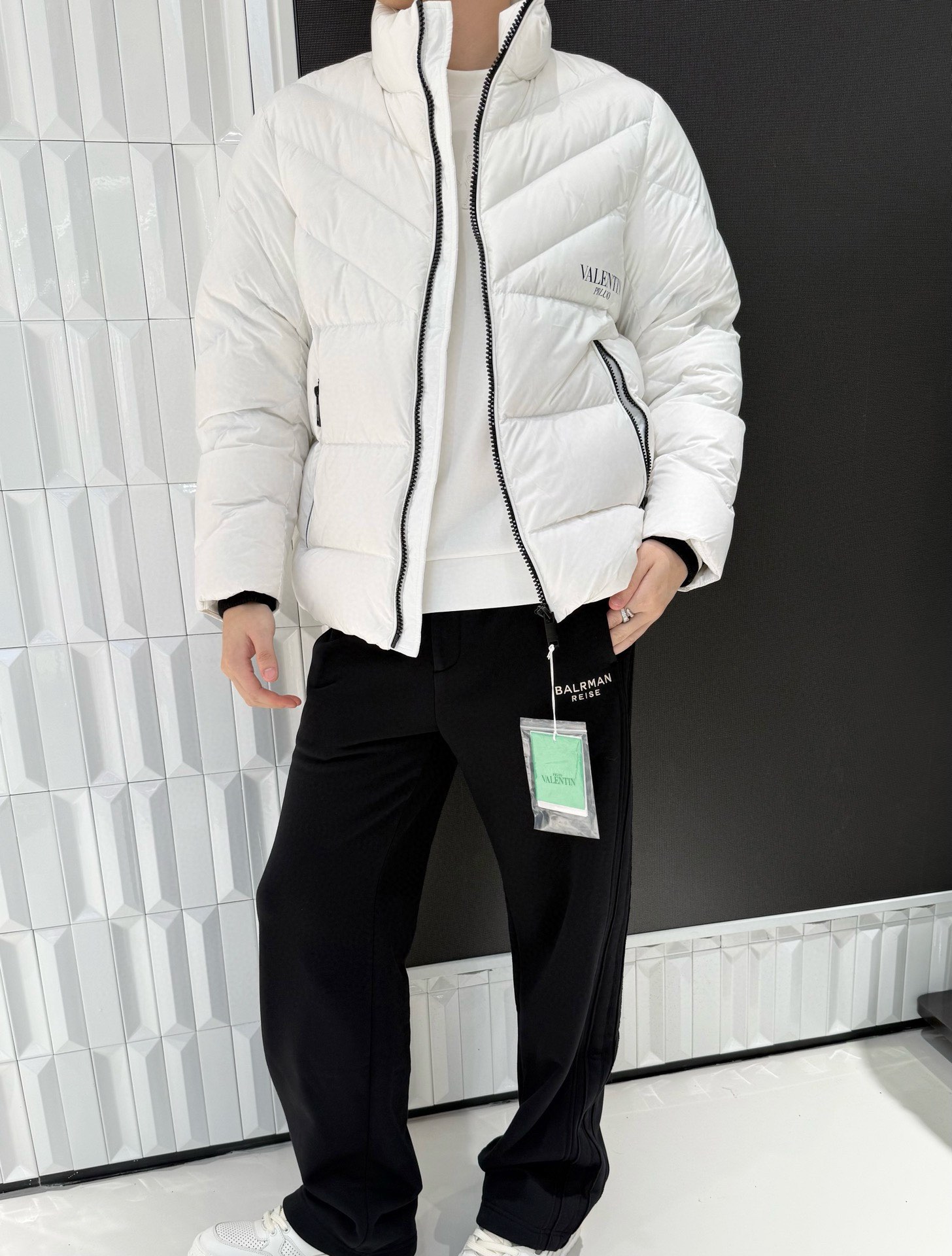 NO:595036,Valentino-2025 high-end new down jacket!  Selected high-quality down filling, high fluffiness, excellent temperature locking and thermal insulation effect, can easily cope with low temperature environments; the outer fabric has good water-repellent properties, and is light in texture, so it does not feel weight-bearing when worn. The main tone of white is simple and elegant, and the stand-up collar design is neat and stylish, effectively resisting the cold wind; the brand 'VALENTIN'  'PRUJO' logo is exquisite and eye-catching, enhancing fashion recognition; black and white contrasting zipper and pocket design, the details highlight the sense of fashion, the short version is fashionable and versatile, and can easily create a variety of styles. Size: 48-56 (model 180/140 wears 50, with Hong Kong Lane Crawford gift box packaging),, valentino, valentino, down jacket, alexander wang19860909华伦天奴-2025高端新款羽绒服！精选高品质羽绒填充,蓬松度高,锁温保暖效果出色,可轻松应对低温环境；外层面料具有良好的防泼水性,且质感轻盈,穿着无负重感.白色主调简约大气,立领设计利落有型,有效抵御寒风；品牌“VALENTIN PRUJO”标识精致醒目,提升时尚辨识度；黑白撞色拉链与口袋设计,细节处彰显潮流感,短款版型时尚百搭,能轻松打造多种风格造型.码数:48-56(模特180/140穿50,配香港连卡佛礼盒包装),,valentino,valentino,down jacket,alexander wang,Men's clothing