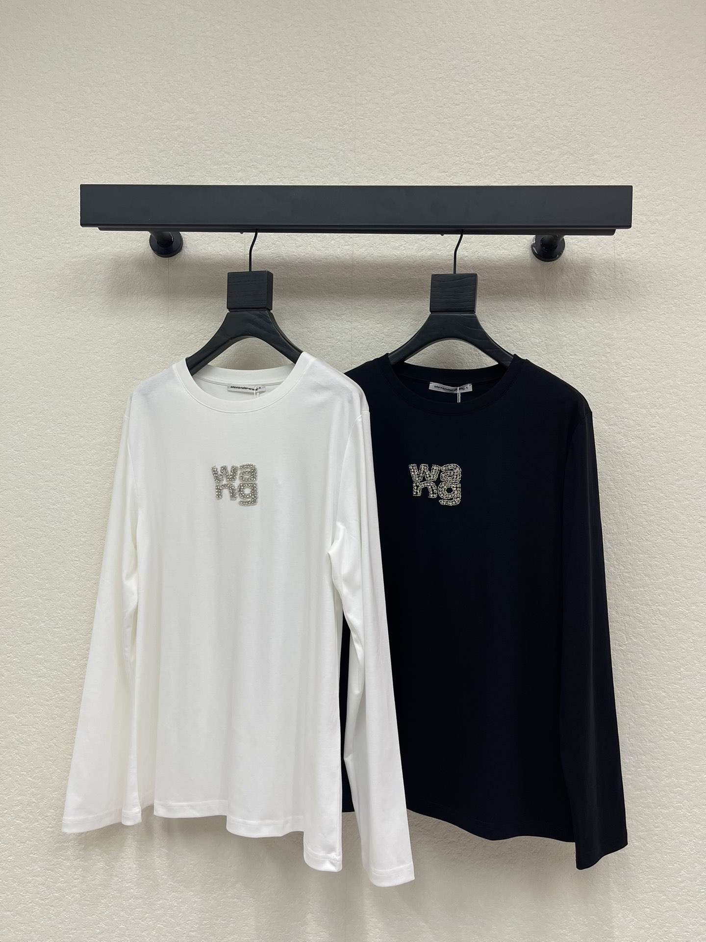 NO:587960,Alexander  wan*25 new hot-drilled beaded round neck long-sleeved T-shirt. Customized YB imported cotton poplin material, breathable and comfortable, full of texture. The round neck long-sleeved top is cut to highlight the brand style. It is made of heavyweight pure cotton with a full drape feeling and a slimming visual effect. It is restored using the washing process.  Uniform black and white color, hot diamond beads on the chest outline the Wang brand logo, the color of the body collides, and the sense of fashion and high-end is immediately apparent, creating a personalized style, fashionable and relaxed, and stylish when worn alone or worn inside. SML,, tees, t-shirt, alexander  wang19860909Alexander wan*25新款烫钻钉珠圆领长袖T恤.定制YB进口棉府绸材质,透气舒适,质感十足,圆领长袖上衣裁剪,凸显品牌格调,采用克重纯棉制成,垂坠感十足,呈现显瘦视觉效果,利用水洗工艺还原均匀黑白本色,胸前烫钻钉珠勾勒出Wang品牌徽标,大身颜色碰撞,时尚高级感立现,打造个性风格,时髦松弛,单穿内搭都出彩时髦.SML,,tees，t-shirt,alexander wang,Women's clothing