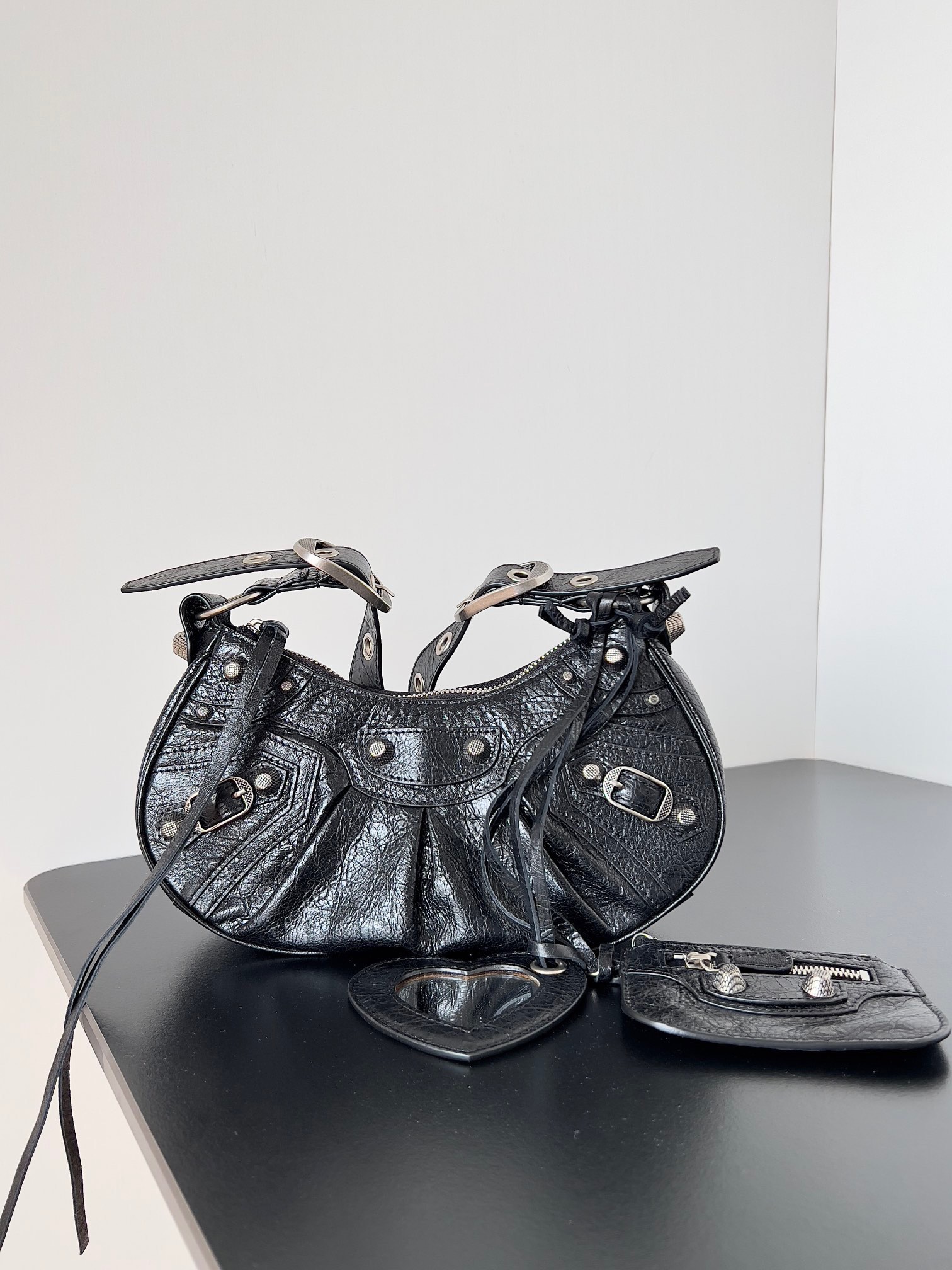 NO:770447,Balenciag Le Cagole Half-Moon Armpit Bag pays homage to the classic motorcycle bag series. The heavy new model is launched~ It has been improved on the traditional motorcycle bag. The adjustable woven shoulder strap has additional eyelets and an external leather card holder. The heart-shaped hanging mirror adopts the classic motorcycle elements. The details are very particular. The upper body is simply obsessed with retro straightforwardness. It is full of boldness and avant-garde with a rock and roll atmosphere. Hot girls must have one of them. I love it!  Model No. 59005 gram leather, small length 26x height 16x width 9.9cm, Balenciaga, balenciaga, balenciaga19860909Balenciag Le Cagole 半月腋下包 致敬经典机车包系列重磅新款王炸登场la～在传统的机车包上做了改良 可调节编织肩带附加孔眼和外挂皮革卡包、心型挂镜沿用经典机车元素 细节非常讲究 上身简直痴迷 复古率性 充满摇滚气息的大胆与前卫 辣妹本辣必须人手一个 爱了！ 款号59005克皮 小号长26x高16x宽9.9cm,巴黎世家,balenciaga,balenciaga,Bag