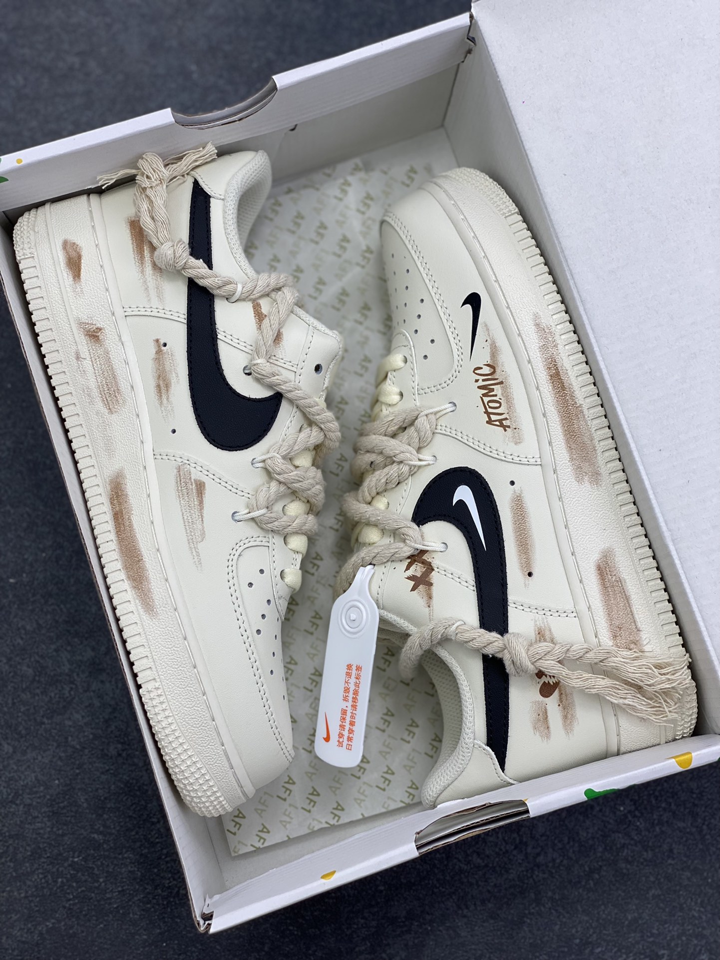 图片[9]-“做旧狂潮”✨订制空军一号板鞋 该定制版球鞋选用原鞋款为Nike Air Force 1\’07空军一号低帮，这是一款基于耐克Air Force 1改造的个性定制款板鞋。融入了强烈的做旧复古风，鞋身的做旧痕迹搭配“ATOMIC”字样设计，增添了街头潮流感；同时采用麻绳材质的鞋带，粗粝的质感与鞋身形成对比，极具辨识度。保留了AF1标志性的鞋型轮廓与舒适脚感，又通过做旧工艺、特殊鞋带和个性印花，打造出独一无二的复古潮流风格，适合追求小众、个性穿搭的潮流爱好者。 货号：CD6951-153 尺码：36 36.5 37.5 38 38.5 39 40 40.5 41 42 42.5 43 44 44.5 45-选品中心