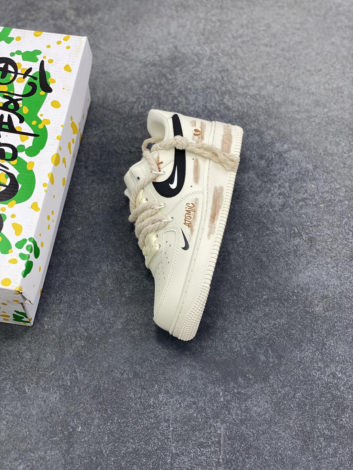 图片[7]-“做旧狂潮”✨订制空军一号板鞋 该定制版球鞋选用原鞋款为Nike Air Force 1\’07空军一号低帮，这是一款基于耐克Air Force 1改造的个性定制款板鞋。融入了强烈的做旧复古风，鞋身的做旧痕迹搭配“ATOMIC”字样设计，增添了街头潮流感；同时采用麻绳材质的鞋带，粗粝的质感与鞋身形成对比，极具辨识度。保留了AF1标志性的鞋型轮廓与舒适脚感，又通过做旧工艺、特殊鞋带和个性印花，打造出独一无二的复古潮流风格，适合追求小众、个性穿搭的潮流爱好者。 货号：CD6951-153 尺码：36 36.5 37.5 38 38.5 39 40 40.5 41 42 42.5 43 44 44.5 45-选品中心