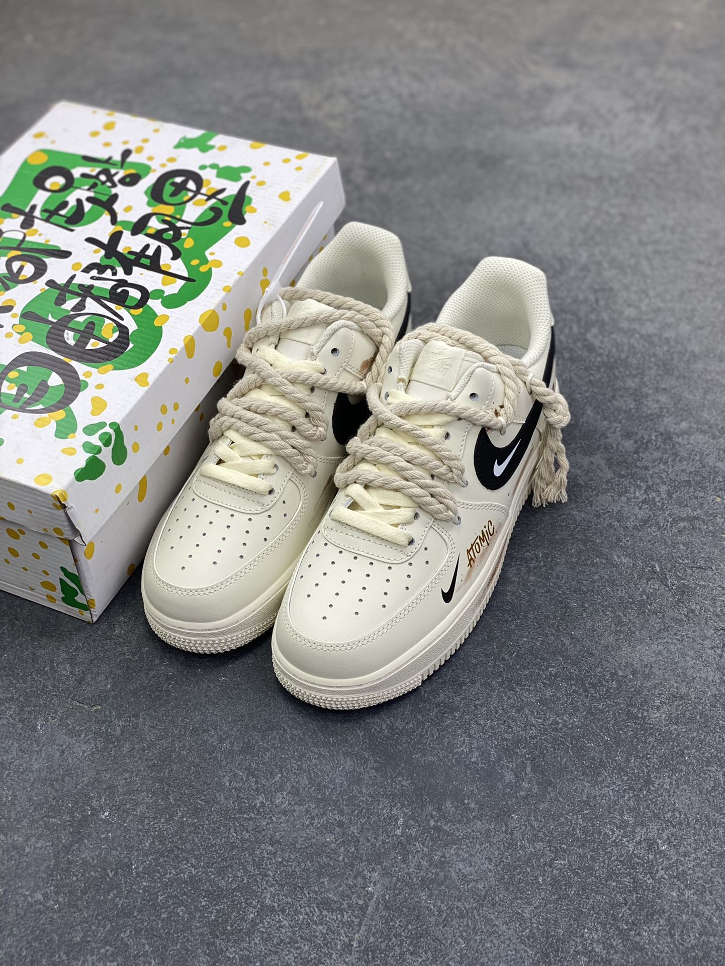 图片[8]-“做旧狂潮”✨订制空军一号板鞋 该定制版球鞋选用原鞋款为Nike Air Force 1\’07空军一号低帮，这是一款基于耐克Air Force 1改造的个性定制款板鞋。融入了强烈的做旧复古风，鞋身的做旧痕迹搭配“ATOMIC”字样设计，增添了街头潮流感；同时采用麻绳材质的鞋带，粗粝的质感与鞋身形成对比，极具辨识度。保留了AF1标志性的鞋型轮廓与舒适脚感，又通过做旧工艺、特殊鞋带和个性印花，打造出独一无二的复古潮流风格，适合追求小众、个性穿搭的潮流爱好者。 货号：CD6951-153 尺码：36 36.5 37.5 38 38.5 39 40 40.5 41 42 42.5 43 44 44.5 45-选品中心
