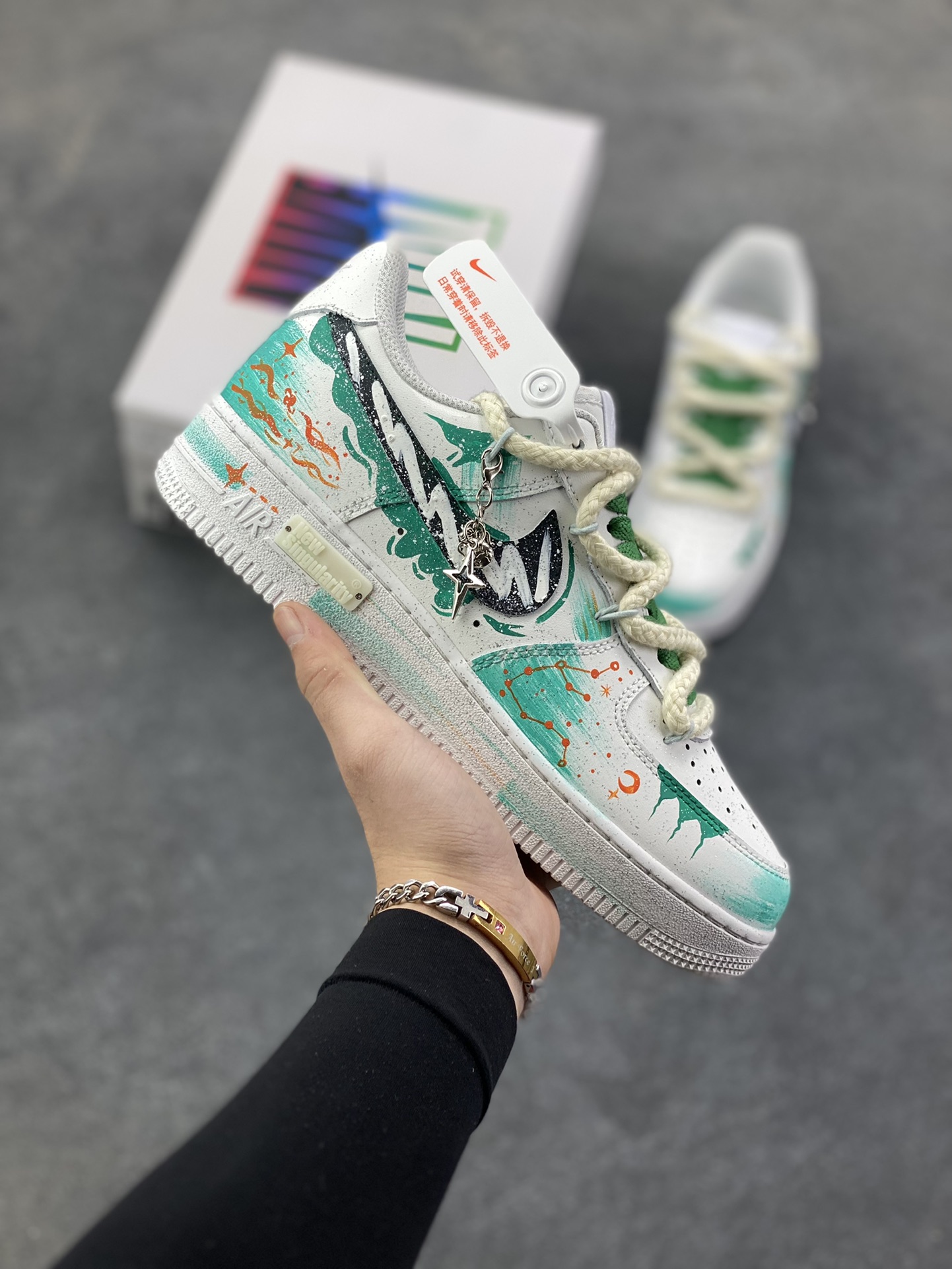 手绘涂鸦“水瓶座”十二星座系列 Nike Air Force 1 “Aquarius”空军一号定制板鞋 白绿渐变如星云晕染鞋身，手绘星座线条缠绕出水瓶座的疏离与浪漫，点缀的星芒与吊坠细节，把宇宙的松弛感踩进日常。牛皮革的质感裹着自在脚感，既是潮鞋也是独属于水瓶的「星轨注脚」——随性、独特，像把一片青空星迹穿在了脚上 货号：星座120-218 尺码：36 36.5 37.5 38 38.5 39 40 40.5 41 42 42.5 43 44 44.5 45-选品中心