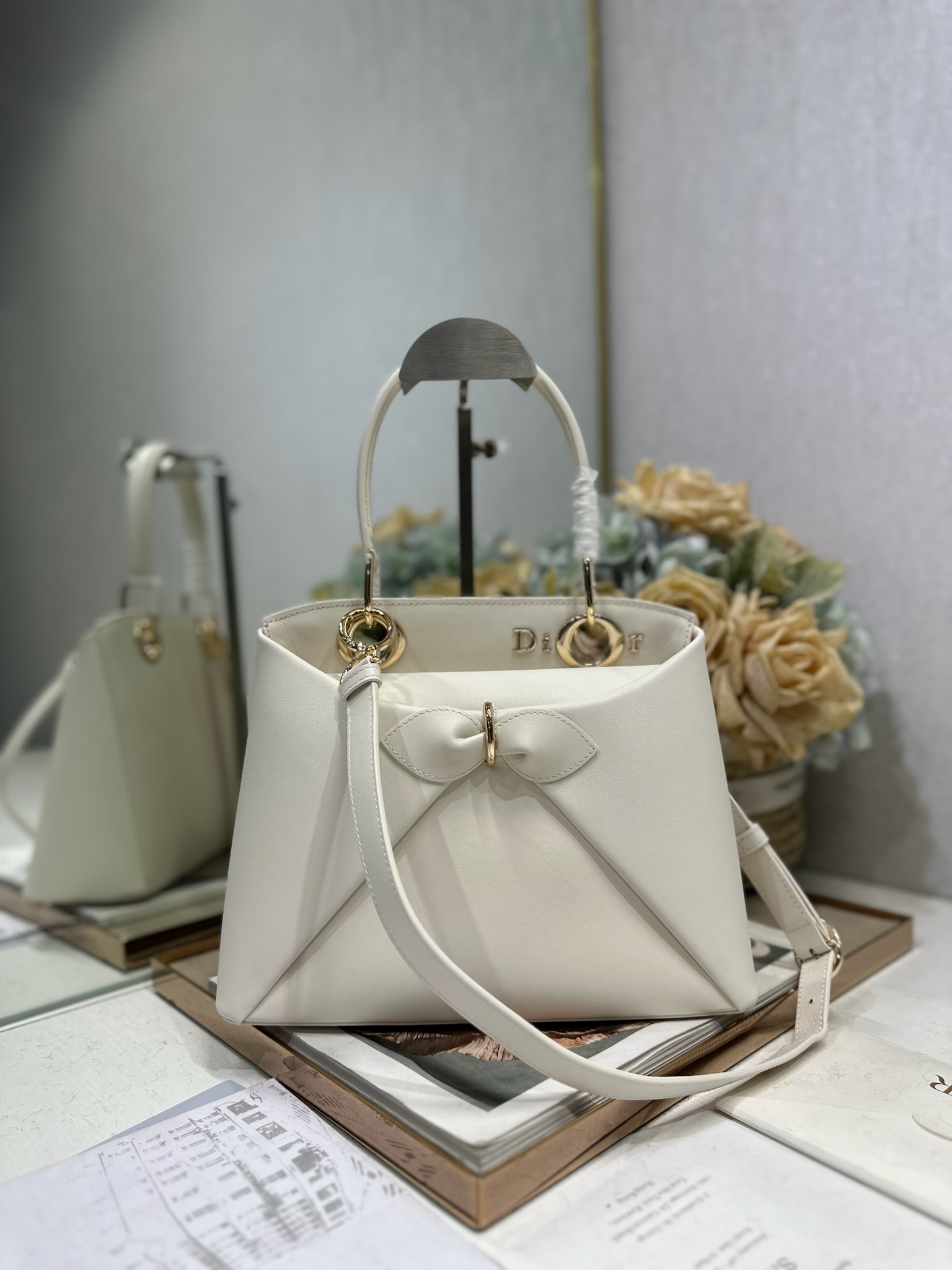 NO:771013,Dior 2026 spring and summer new product #Bowknot Handbag 'White' has a newly designed silhouette and shape, rich colors, and is suitable for many people!  Just the right balance between exaggeration and elegance!  Its design is inspired by the Cigale dress designed by Mr. Dior ~ the three-dimensional trapezoidal body + single handle, the shape has an elegant and majestic tone. The appearance of the bag is relatively low-key, with almost no obvious big logo. Looking closer, it turns out that Anderson has integrated the Dior letter logo and the round hole of the bag handle. The bag is recognizable, and it is not ostentatious at all. The whole bag exudes a sense of quiet luxury!  It is worth mentioning that this bag is also equipped with a long leather shoulder strap. Especially when traveling, you can put on the long shoulder strap, which not only frees your hands, but also makes people relaxed and casual~ Model 0737 Size 28*10*22 (length*width*height), Dior, dior, dior19860909Dior 2026 春夏新品#蝴蝶结手提包「白色」 新设计的轮廓与造型,配色 丰富,适配多人！在夸张与优雅之间恰到好处！它的设计灵感源于迪奥先生设计的 Cigale礼服~立体的梯形包身+单手柄,造型自带优雅大气的腔调.包包的外观比较低调,几乎没有什么明显的大Logo.离近点再看,才发现原来Anderson把Dior字母Logo和包包提手的圆孔融合到了一起. 包包既有辨识度,也完全不是张扬挂的,整体散发着那种不动声色的高级感！值得一提的是,这款包还搭配了一条皮质长肩带.尤其出门旅行的时候就可以换上长肩带,既解放了双手,还衬得人轻松又随性~ 型号0737 尺寸28*10*22（长*宽*高）,迪奥,dior,dior,Bag