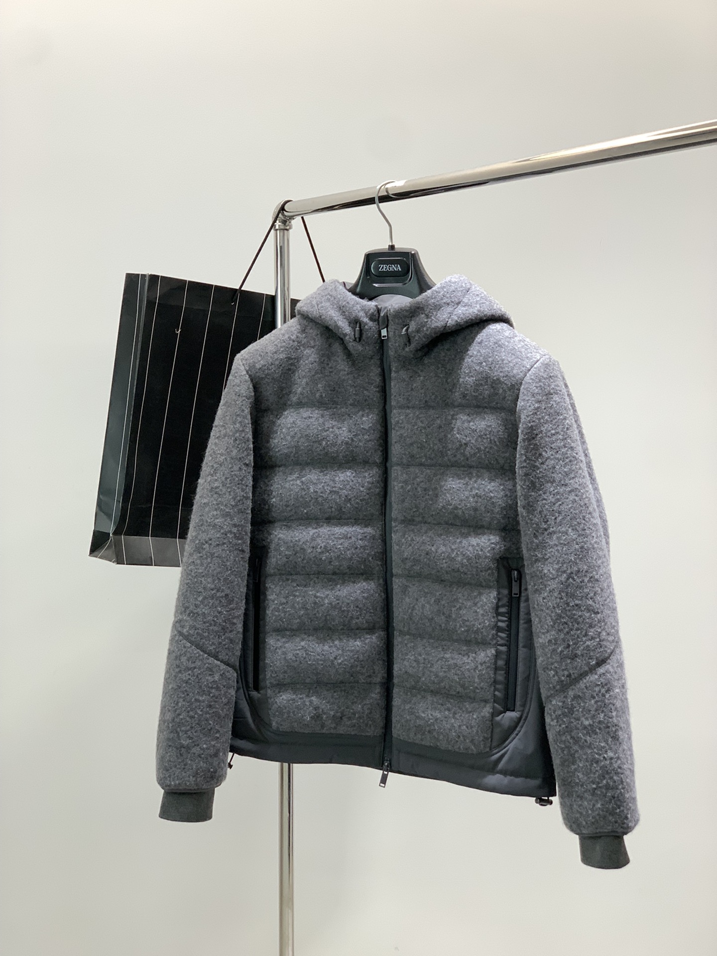 NO:608897,, Jelia - Men's Yangtze yarn reinforced wool splicing technical fiber white goose down filled hooded down jacket About style and design The Oasi WOOL LITE series of the Z family's high-end line, the Oasis wool series, has risen to a more unique quality of high-end fabrics, in line with the Z family's consistent 'fabric is king' style. There is no need to deliberately create an old money style, it is old money in the bones!  A set of woolen down jackets are not just pure wool shells. The left and right sides are connected from the armpits to the hem. They are spliced with functional technical fibers using a draping deconstruction method. The arc deconstruction of the front piece, the right-angled line of the back hem, and the collision of different materials of the same color make the visual contrast very harmonious. The sideways splicing suppresses the swelling of the body to a certain extent, and has the effect of narrowing and slimming down.  An all-in-one hooded model, the hood is vertically cut, and the inside of the hood collar is spliced with technical fibers that are consistent with the sides. The hood has a high stand-up collar, which can protect the neck extremely well when the zipper is closed. The waterproof zipper placket is lined with half windproof and waterproof tape. Large body  Horizontal quilting is done, and each quilting is a unique four-needle and six-thread process, which not only suppresses the expansion of goose down, but also increases the linear feel of the wool shell. The quilting of the sleeve arms is a spiral line, which is different from the straight lines of the body and is more in line with dynamic aesthetics.  About fabrics and technology: 57.6 sheep wool, 25.5 polyester fiber, 16.9 lyocell fiber, wool yarn from Biella, Germany  Yarn Yangtze yarn, ultra-fine Merino wool, blended with Tencel Lyocell, is blessed with Basulan technology, knitted with high-speed automated needles on German Karl Mayer equipment worth 1.5 million, and processed by shrinkage. The width is reduced to only 125cm. The dosage is 1.5 times that of ordinary similar styles. The cost is high as you can imagine, but at the same time, the shrinkage process brings the tightness and high texture of the wool fabric, and the anti-pilling effect is good.  Polyester fiber lining, white goose down filling with 90% down content, RDS certified, traceable, large velvet, few feather stalks, as light as a cloud and not weighing down the body, lining with locking velvet grid, fill power 800+. Full YKK custom waterproof zipper size S, M, L, size chart S Bust 108 Shoulder Width 47 Sleeve Length 61 Clothing Length 66. M Bust 112 Shoulder Width 48 Sleeve Length 62 Clothing Length 67.  L Bust 116 Shoulder width 49 Sleeve length 63 Clothes length 68.,,down jacket,hats,alexander wang19860909,杰力亚 -男款扬子纱线强缩羊毛拼接科技纤维白鹅绒填充连帽羽绒服 关于款式及设计 Z家高端线的Oasi WOOL LITE系列,即绿洲羊毛系列,上升到一种更独特品质的高端面料,符合Z家一贯地“面料为王”的做派,不用刻意去塑造老钱风,是骨子里自带的old money！ 羊毛呢的一组羽绒服,不是单纯的羊毛外壳,左右侧身,从腋下开始衔接到下摆处,以立裁解构的手法拼接了机能型的科技纤维,前片弧线解构,后摆直角线条,同色系的不同材质相碰撞,视觉对比很和谐.侧身的拼接在一定程度上压制了大身的膨胀感,有收窄和显瘦的效果. 一体式的连帽款,帽兜立裁,帽领内里拼接了与侧身一致的科技纤维,帽领高位立领,在门襟拉链拉合的状态下,可以极好的防护脖颈.防水拉链的门襟,内衬半截防风防水压胶条.大身做了横向的绗缝车线,每一道绗缝都是别致的四针六线工艺,既压制鹅绒的膨胀感,也增加了羊毛呢外壳的线条感,袖臂的绗缝是螺旋线条的,区别于大身的直线线条,更符合动态美学. 关于面料及工艺 57.6绵羊毛25.5聚酯纤维16.9莱赛尔纤维,羊毛纱线来自德国Biella Yarn扬子纱线,超细的美丽诺羊毛,混纺天丝莱赛尔,经巴素兰工艺加持,在价值150万的德国卡尔迈耶设备上,由高速自动化机针编织制成,并经过强缩羊毛处理,幅宽缩到只有125cm,用量是普通类似款式的1.5倍,成本可想而知的高昂,但同时也因强缩工艺带来的是羊毛织物的紧实和高质感,抗起毛气球效果好. 内里聚酯纤维,填充绒子含量90的白鹅绒,RDS认证,可溯源,绒朵大,羽梗少,云朵般轻盈不压身,内里锁绒格充,蓬松度800+.全衣YKK定制防水拉链 尺码S,M,L, 尺码表S胸围108肩宽47袖长61衣长66.M胸围112肩宽48袖长62衣长67. L胸围116肩宽49袖长63衣长68.,,down jacket,hats,alexander wang,Men's clothing