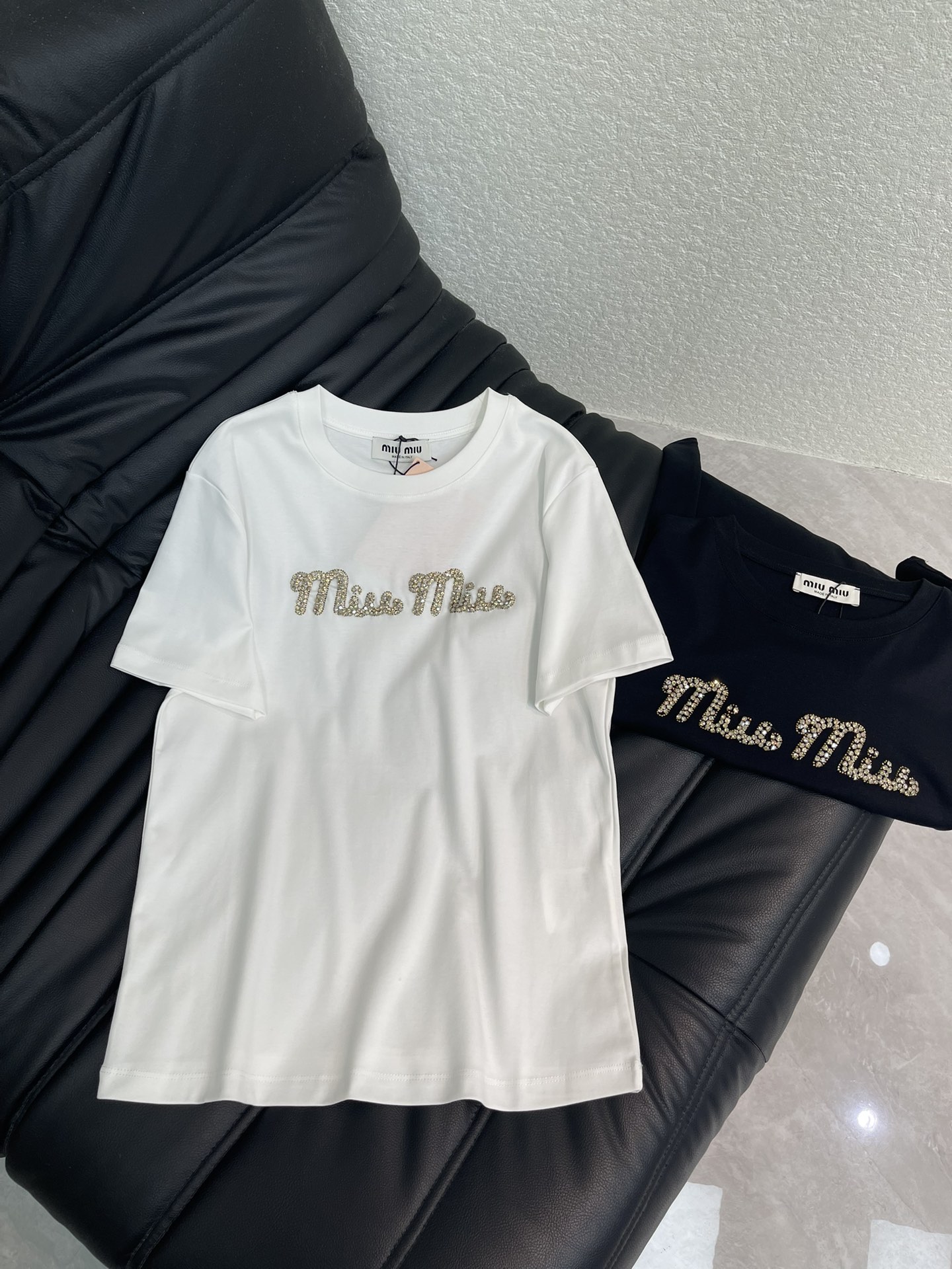 NO:592110,Miumi*26 new early spring beaded and rhinestoned short-sleeved T-shirt. Customized YB native cotton material, breathable and comfortable, full of texture, regular short-sleeved T-shirt cut, highlighting the brand style, made of heavyweight pure cotton, slightly stretchy, showing a slimming visual effect, with beaded rhinestones on the chest, and also  The original brand letter logo, combined with the gorgeous flashing reflective effect, highlights the highlights and makes it look stylish when worn alone. The gloss and refraction effect make the outfit more eye-catching and stylish. SML,,miumiu,T-shirt,tees,t-shirt,alexander  wang19860909Miumi*26早春新款钉珠烫钻短袖T恤.定制YB原生全棉材质,透气舒适,质感十足,常规短袖T恤裁剪,凸显品牌格调,采用克重纯棉制成,略带有弹力,呈现显瘦视觉效果,胸前用订珠水钻工艺,还原品牌字母徽标,配合闪烁反光的华丽效果,亮点突出,单穿内搭都出彩时髦,光泽与折射效果让穿搭更为吸睛洋气.SML,,miumiu,T-shirt,tees，t-shirt,alexander wang,Women's clothing